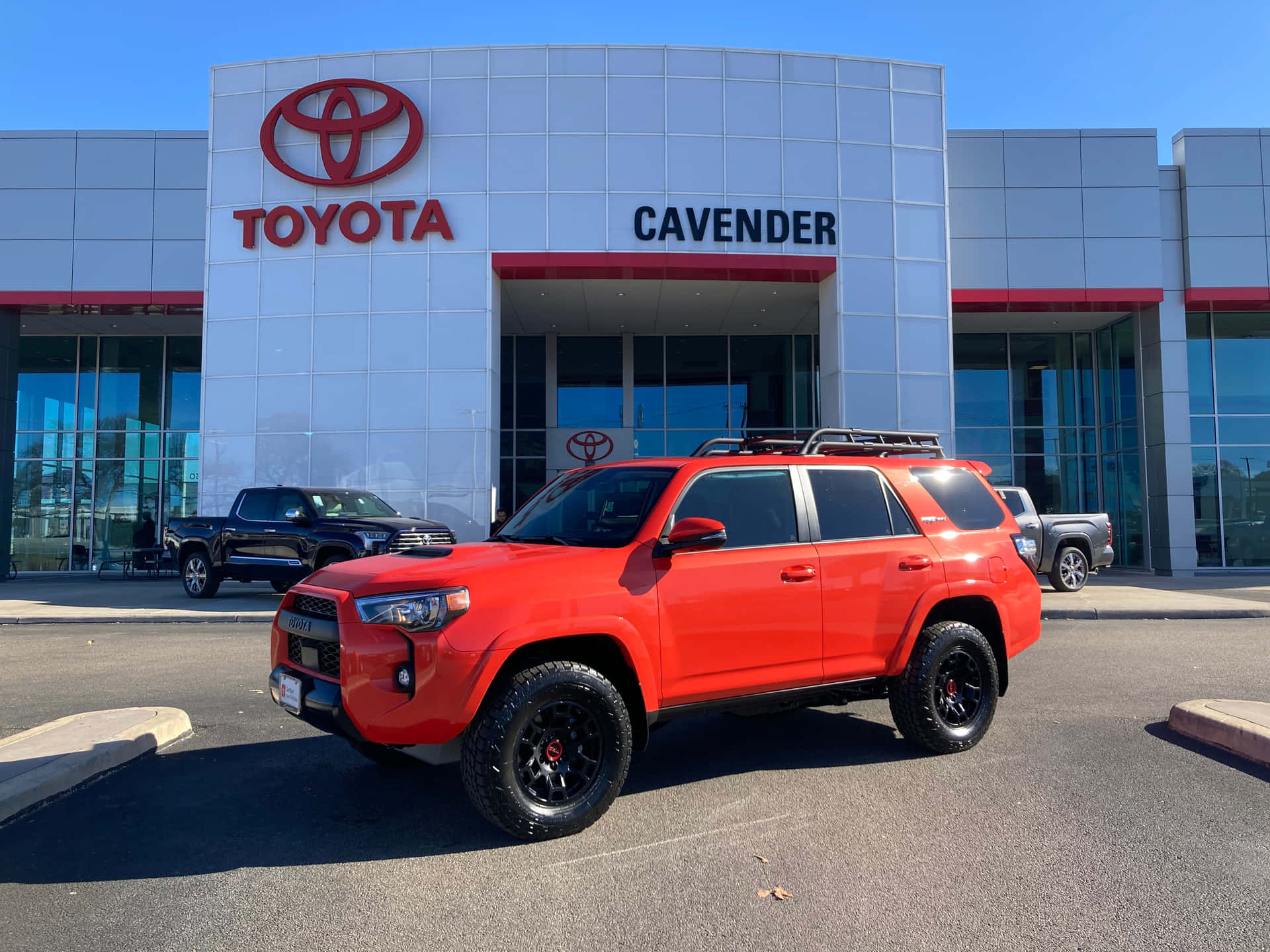 A Red Toyota 4runner Parked Outside Of A Toyota Dealer