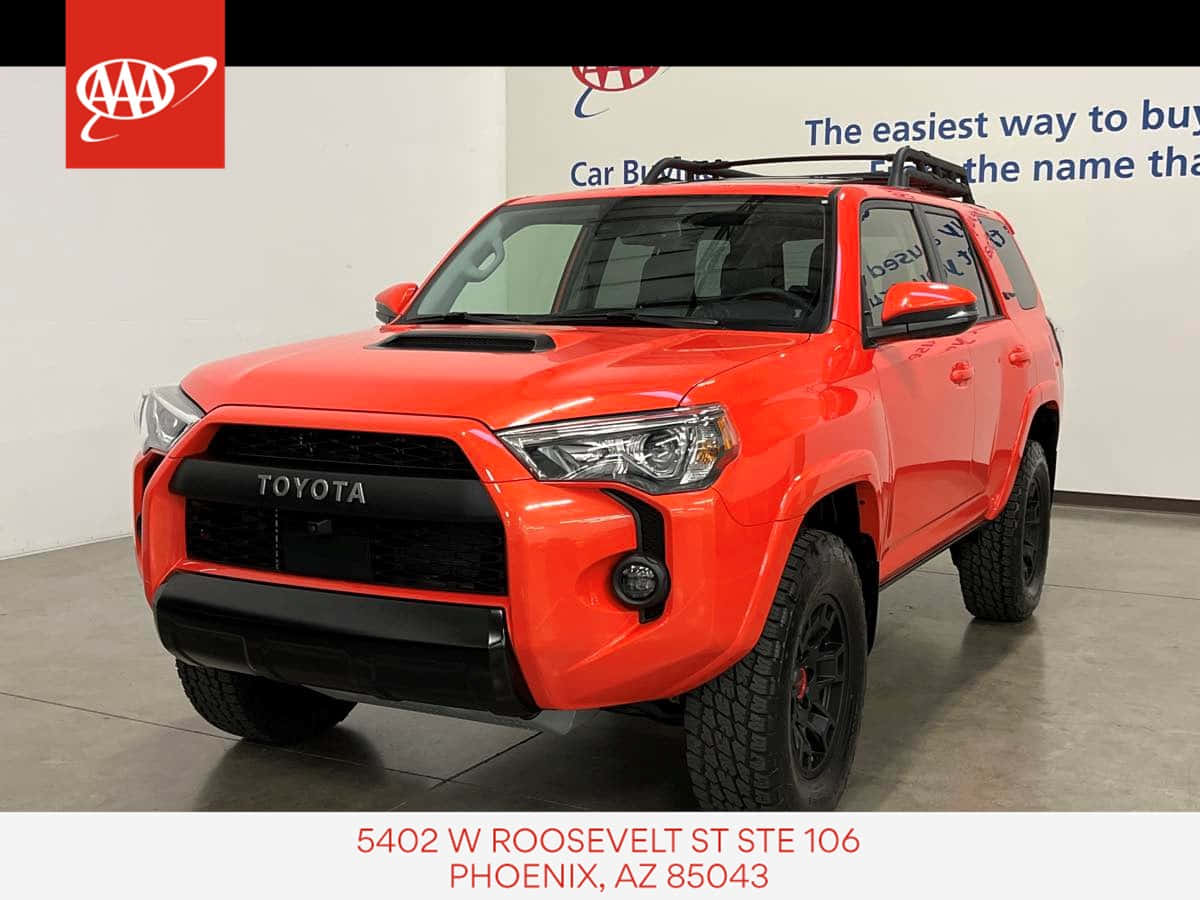 A Red Toyota 4runner Is Parked In A Showroom