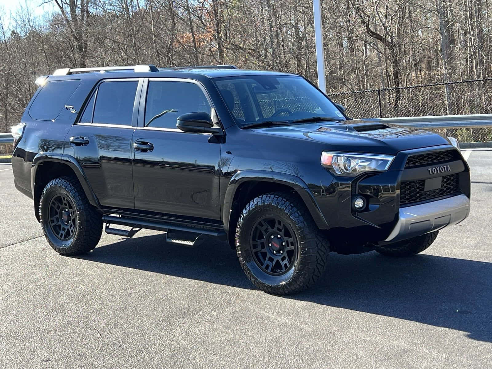 A Black Toyota 4runner Is Parked In A Parking Lot