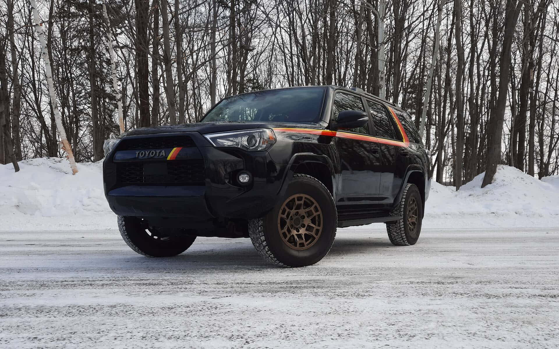 A Black Toyota 4runner Is Parked In The Snow
