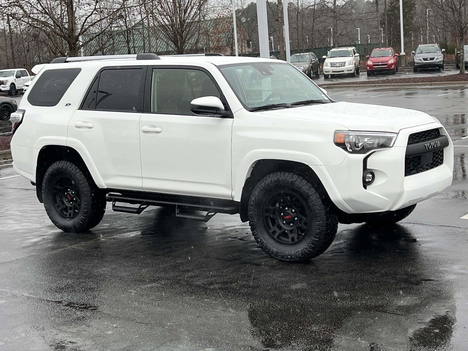 A White Toyota 4runner Is Parked In A Parking Lot