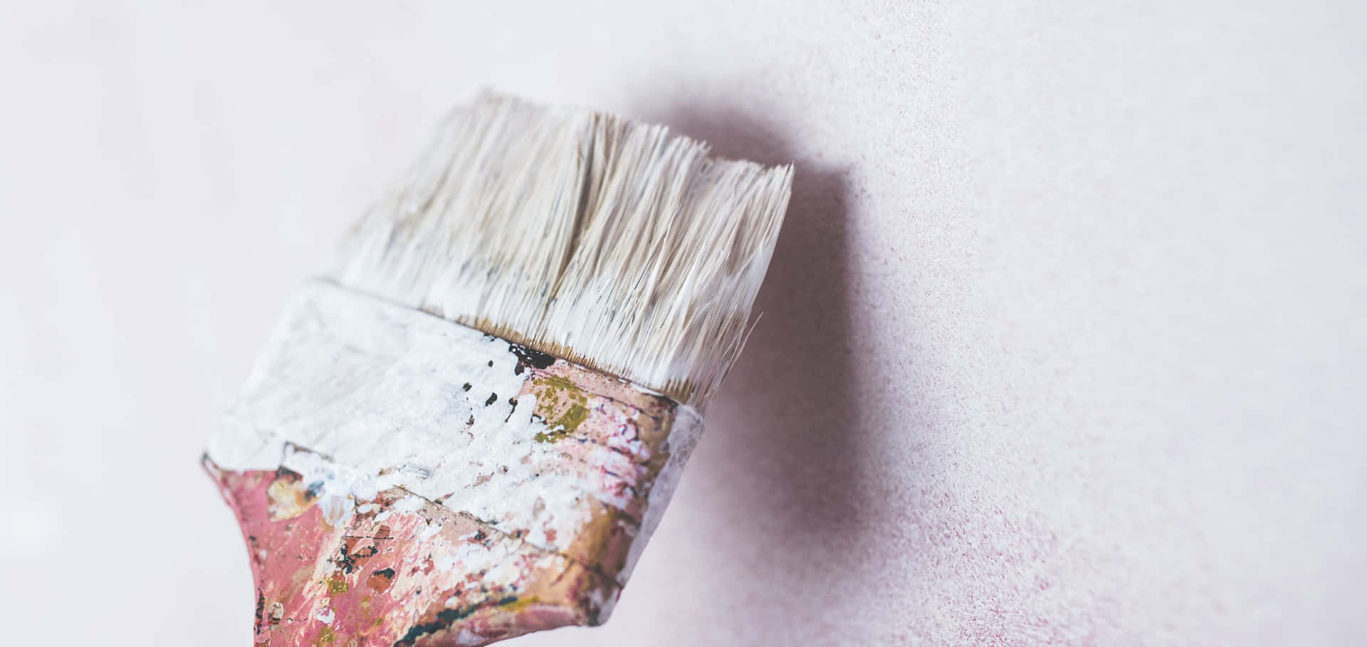 A Paint Brush Is On A White Wall Wallpaper