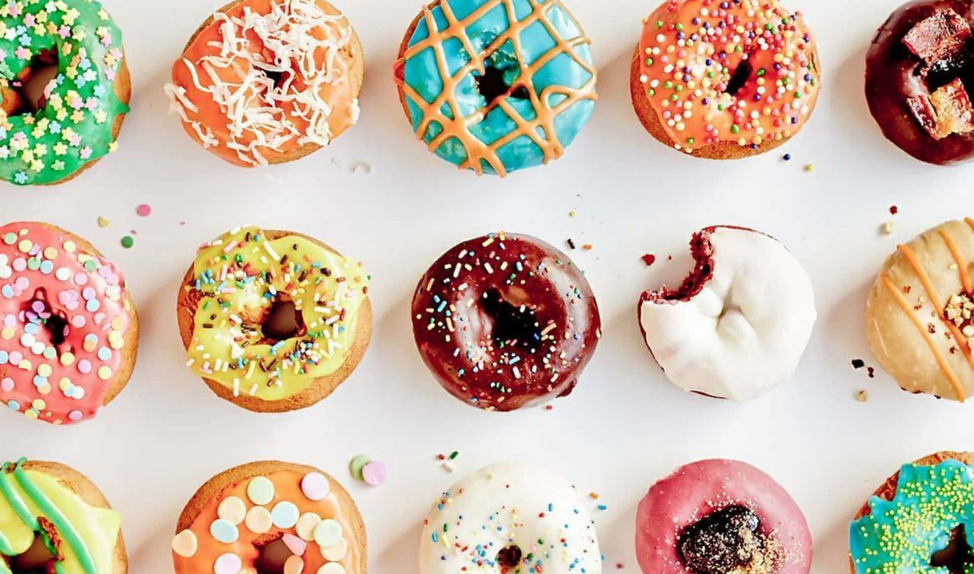 A Group Of Colorful Donuts Are Arranged On A White Surface