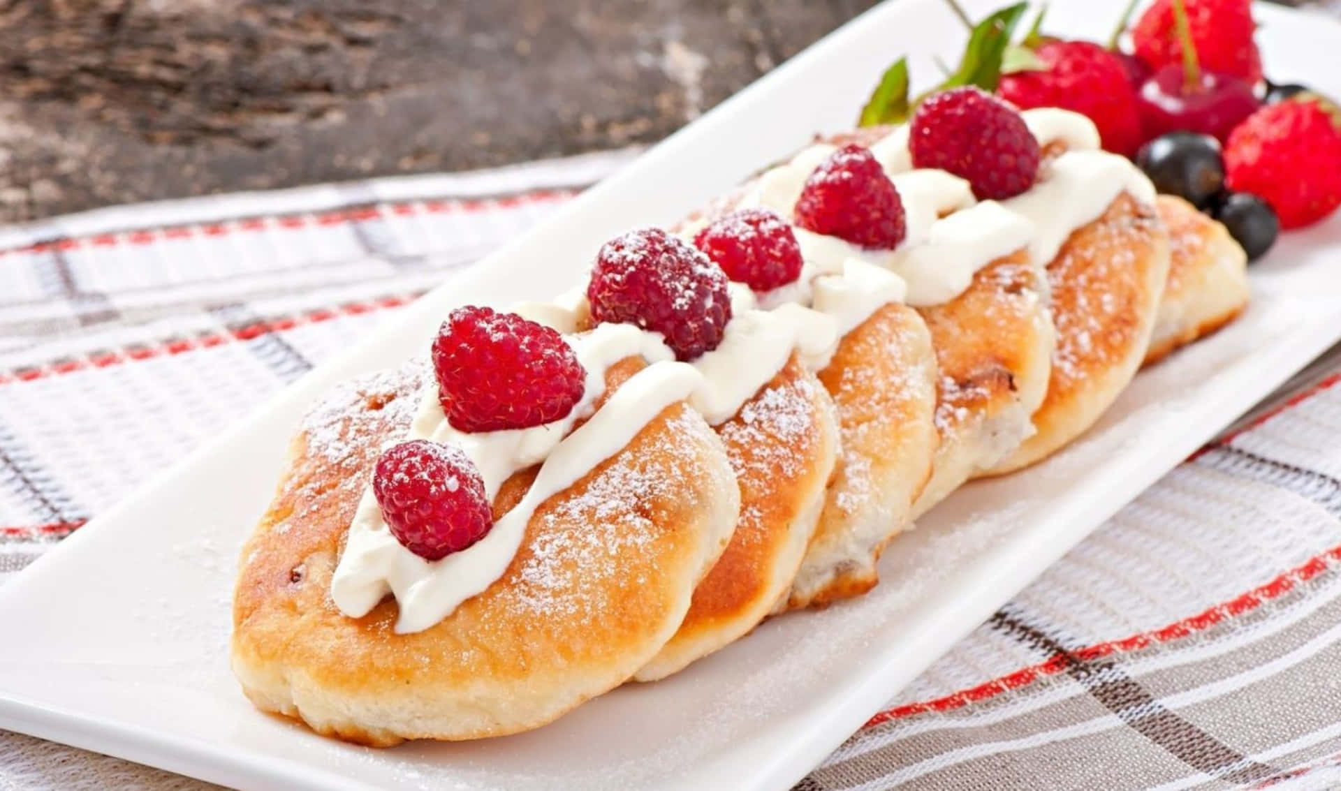 A Plate With A Pastry With Berries And Cream
