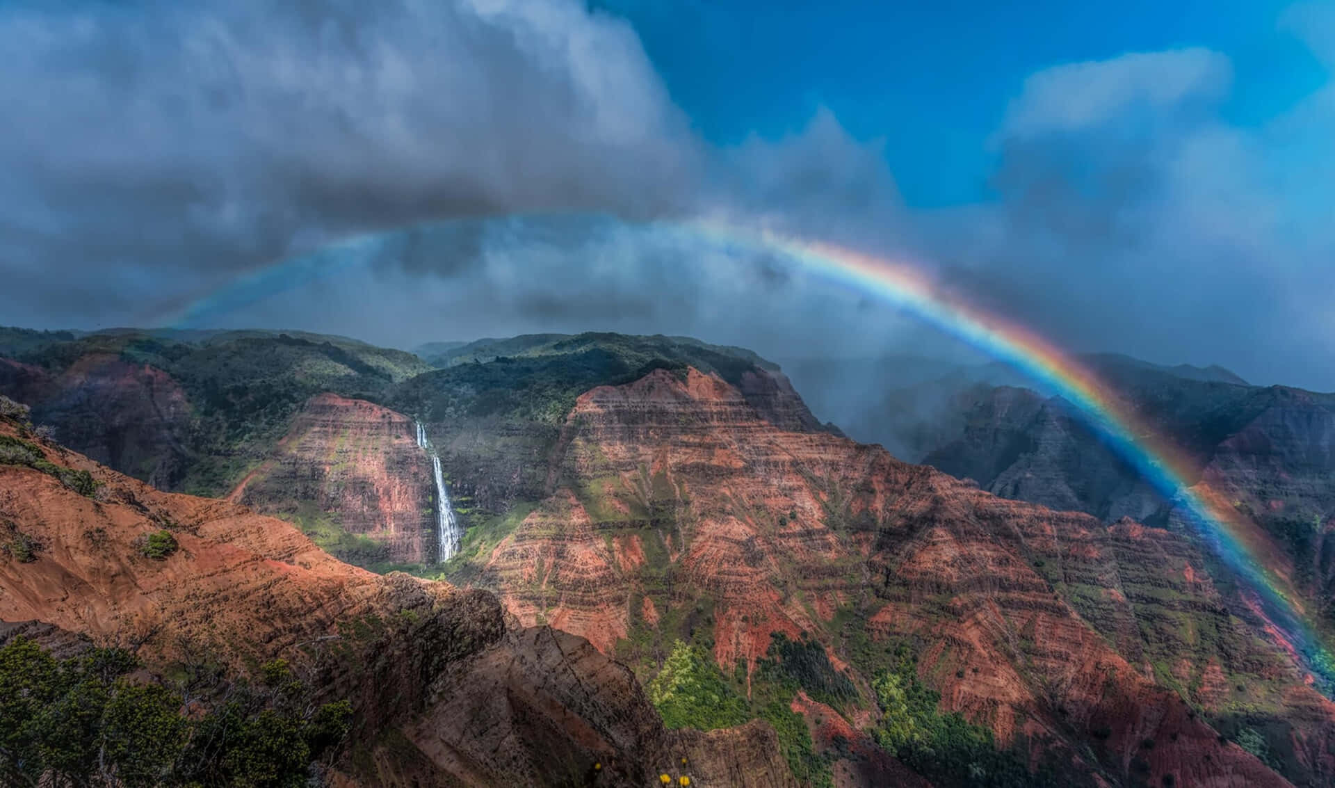 rainbow over a canyon with a waterfall