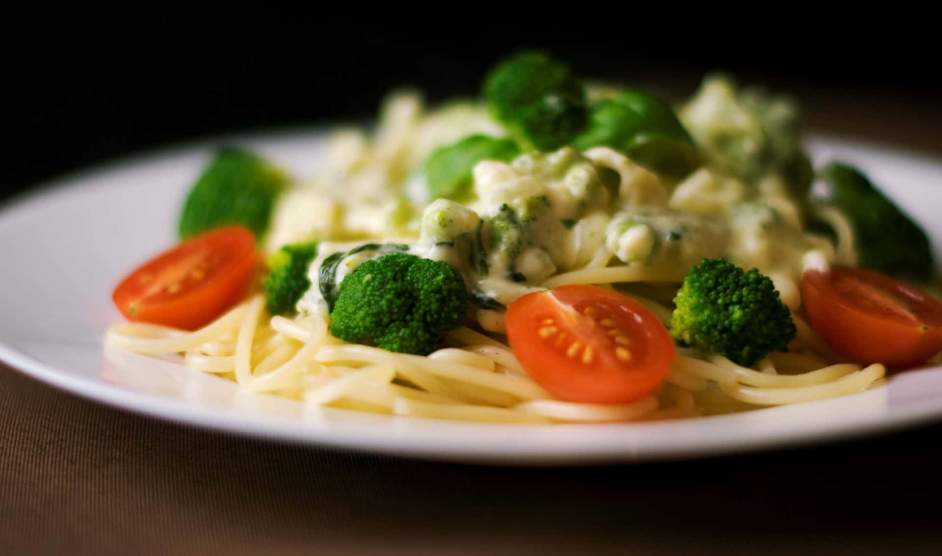 A Plate Of Pasta With Broccoli And Tomatoes