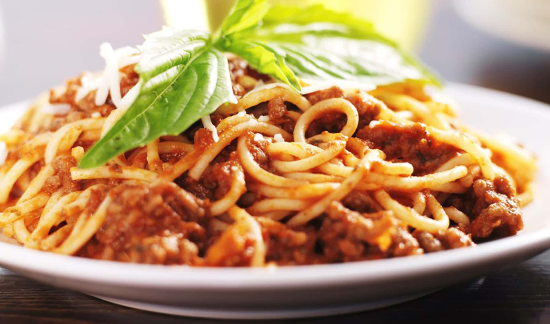 A Plate Of Spaghetti With Meat And Basil
