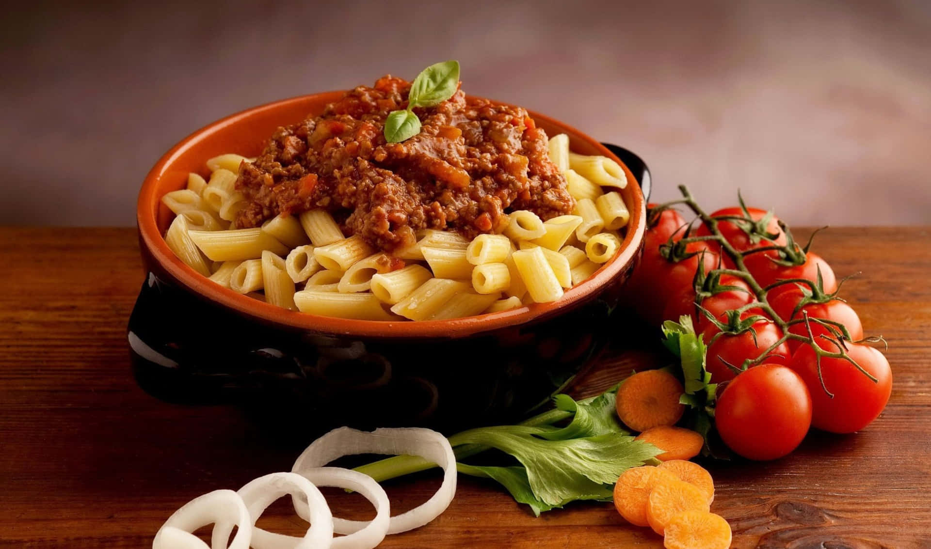 A Bowl Of Pasta With Meat And Vegetables