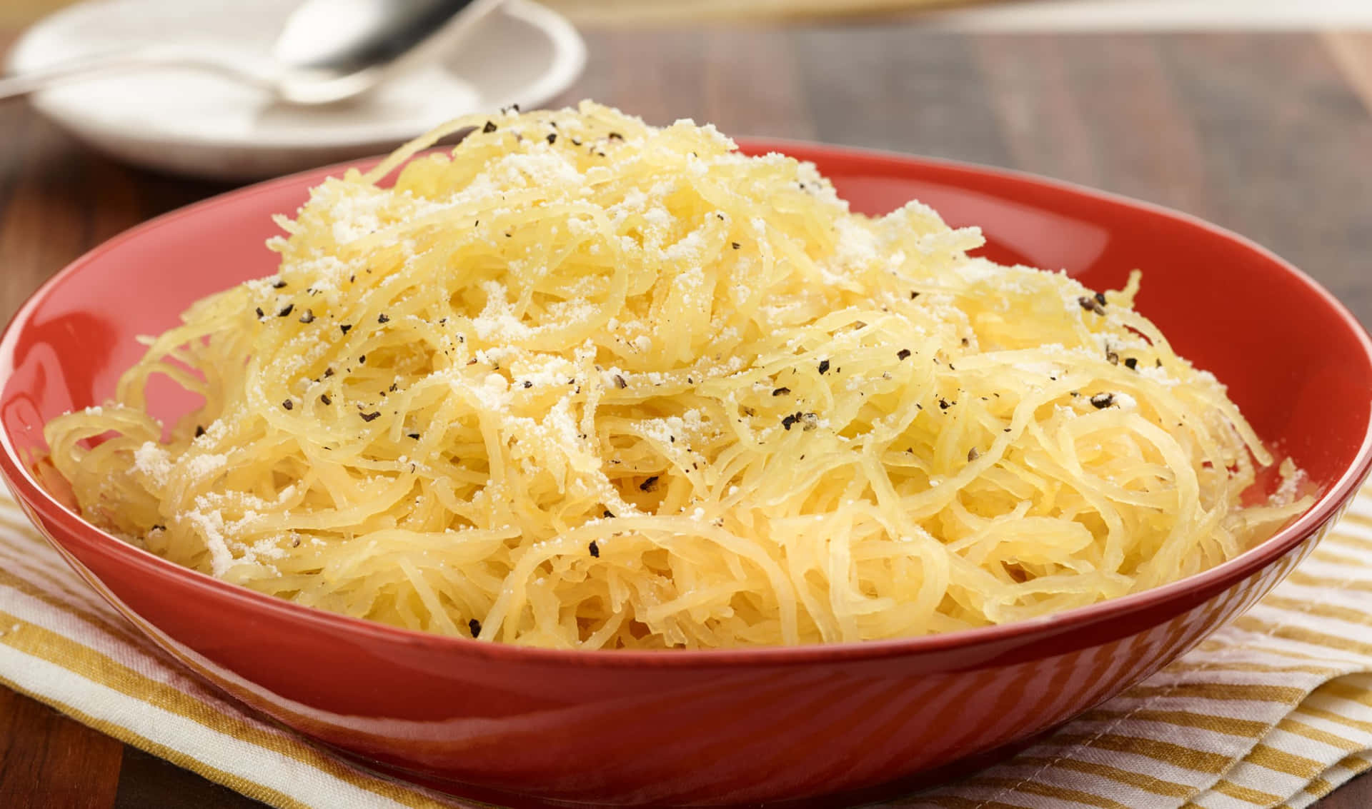 A Bowl Of Spaghetti With Parmesan Cheese
