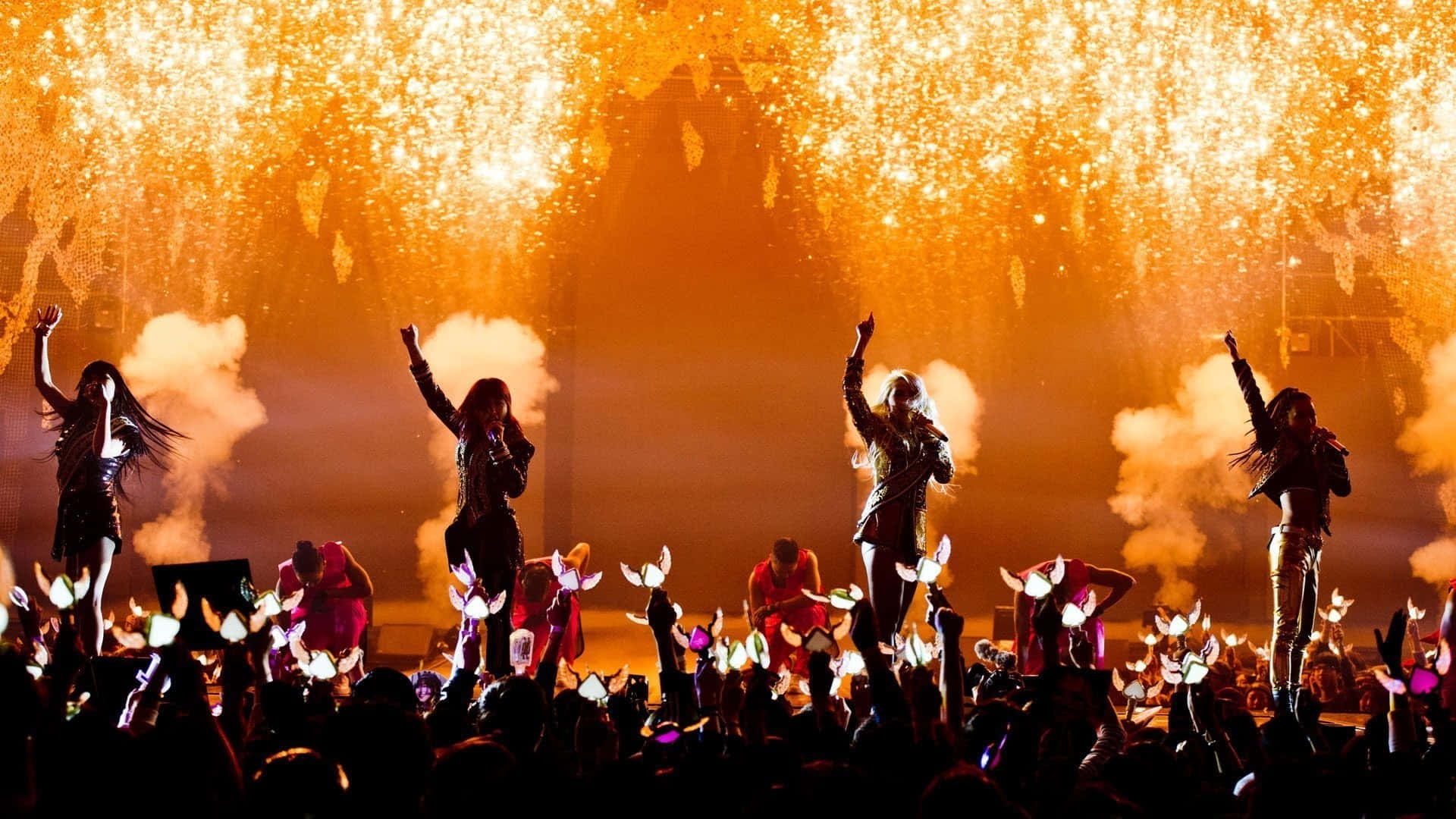 A Group Of Girls On Stage With Fireworks