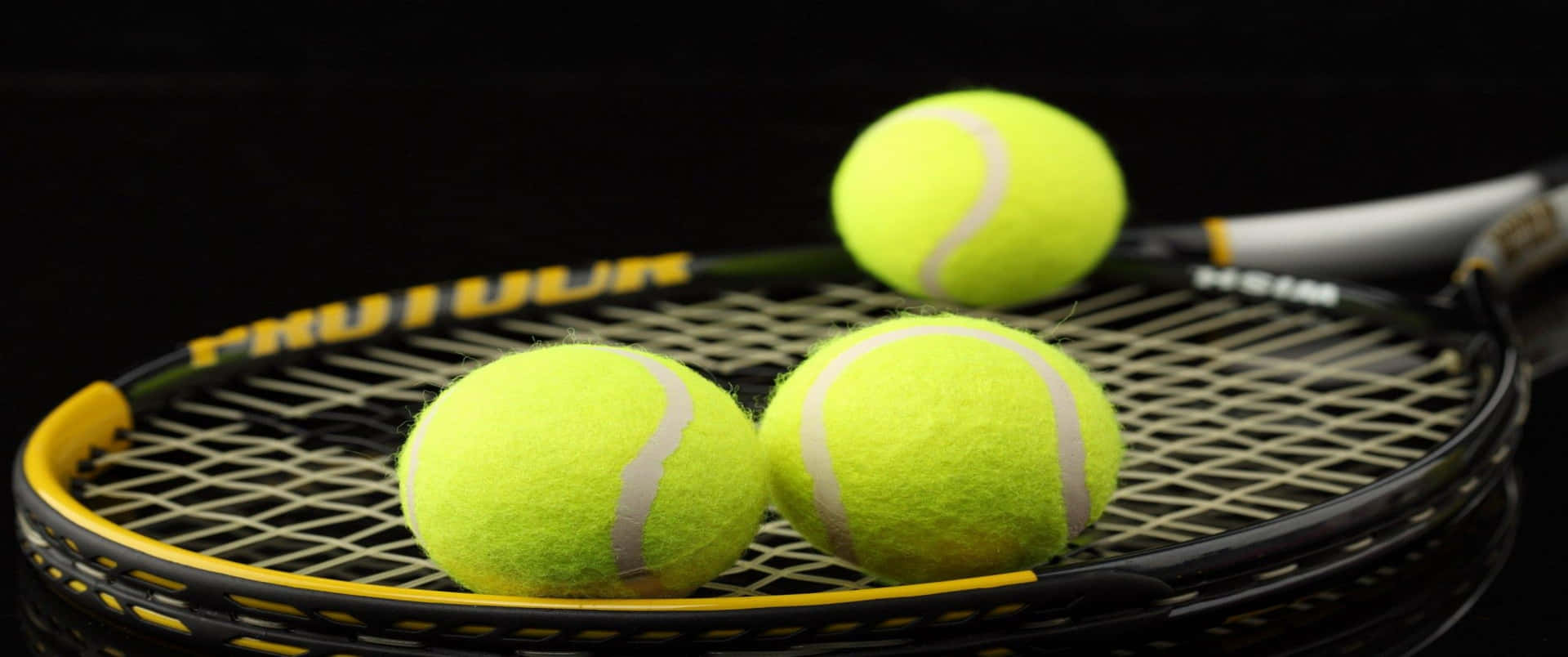 Three Tennis Balls On A Racket