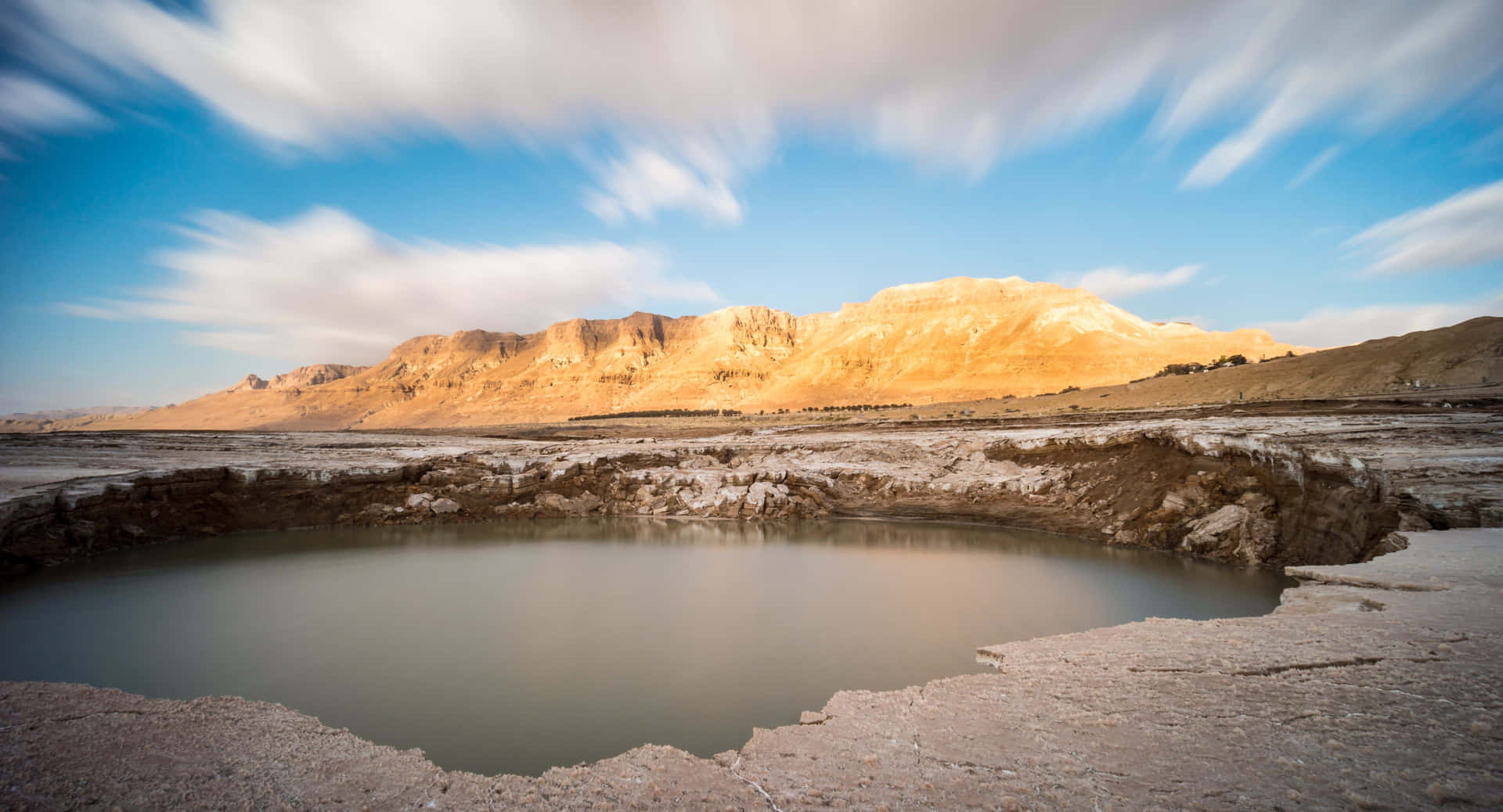 Unapequeña Piscina En El Desierto Con Montañas Al Fondo Fondo de pantalla