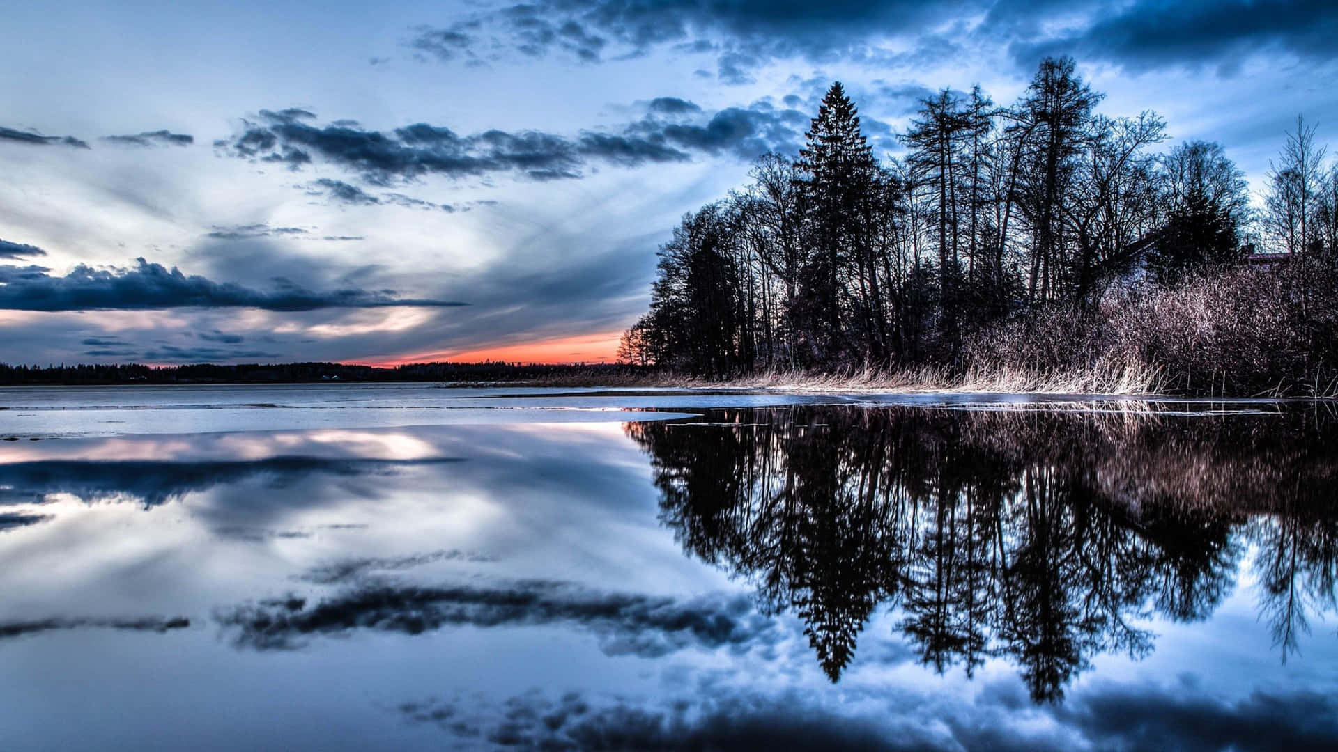 A Lake With Trees And Clouds In The Background Wallpaper