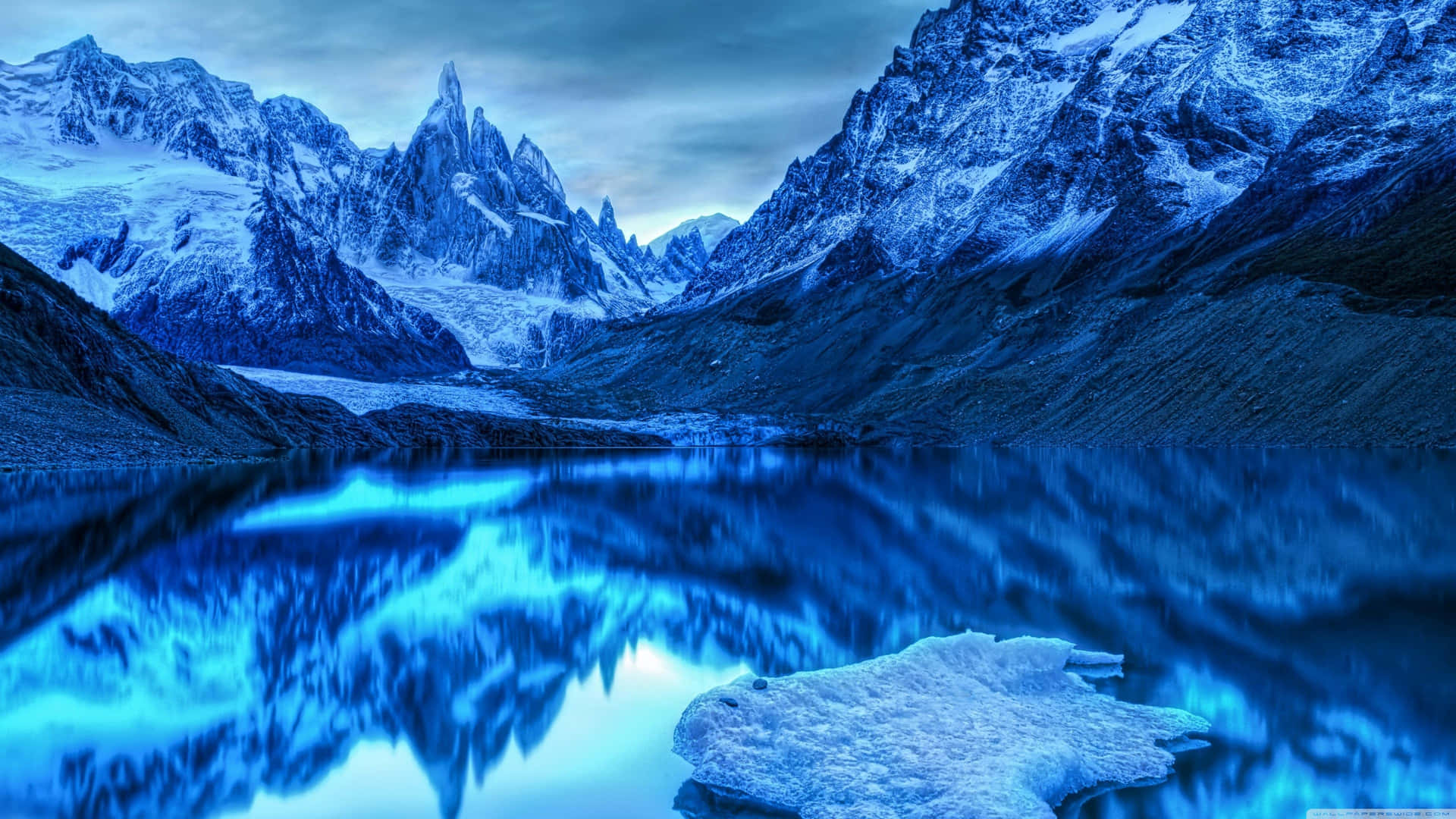 En sø med isbjerge og bjerge i baggrunden Wallpaper