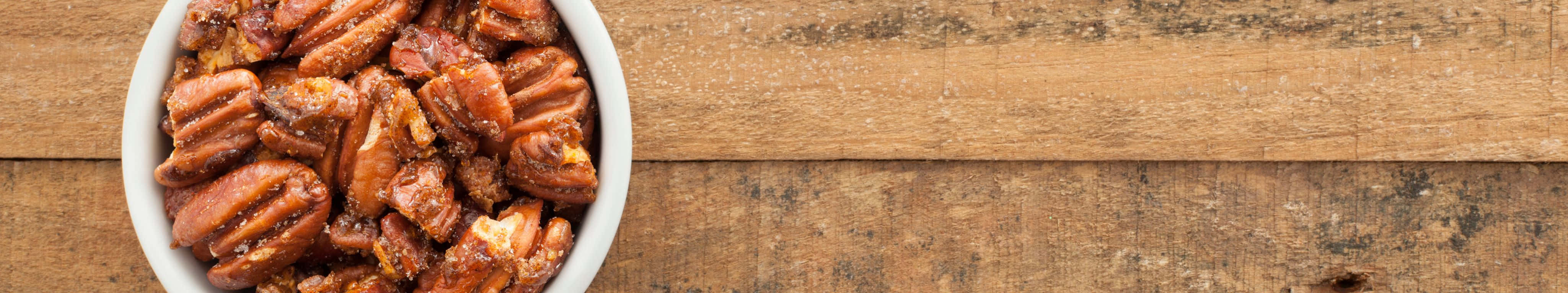 A Bowl Of Dried Nuts On A Wooden Table Wallpaper