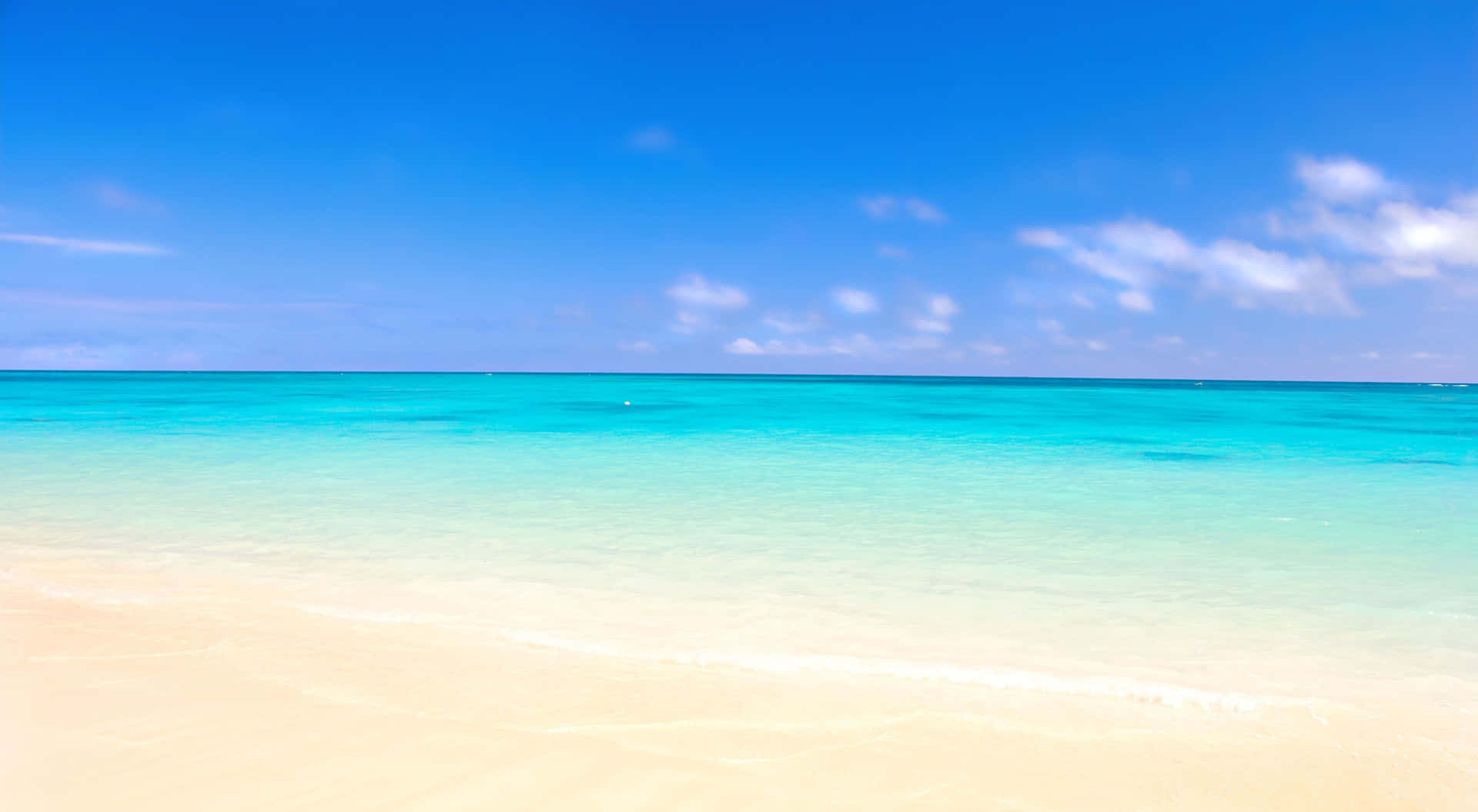 A Beach With Clear Blue Water And Sand