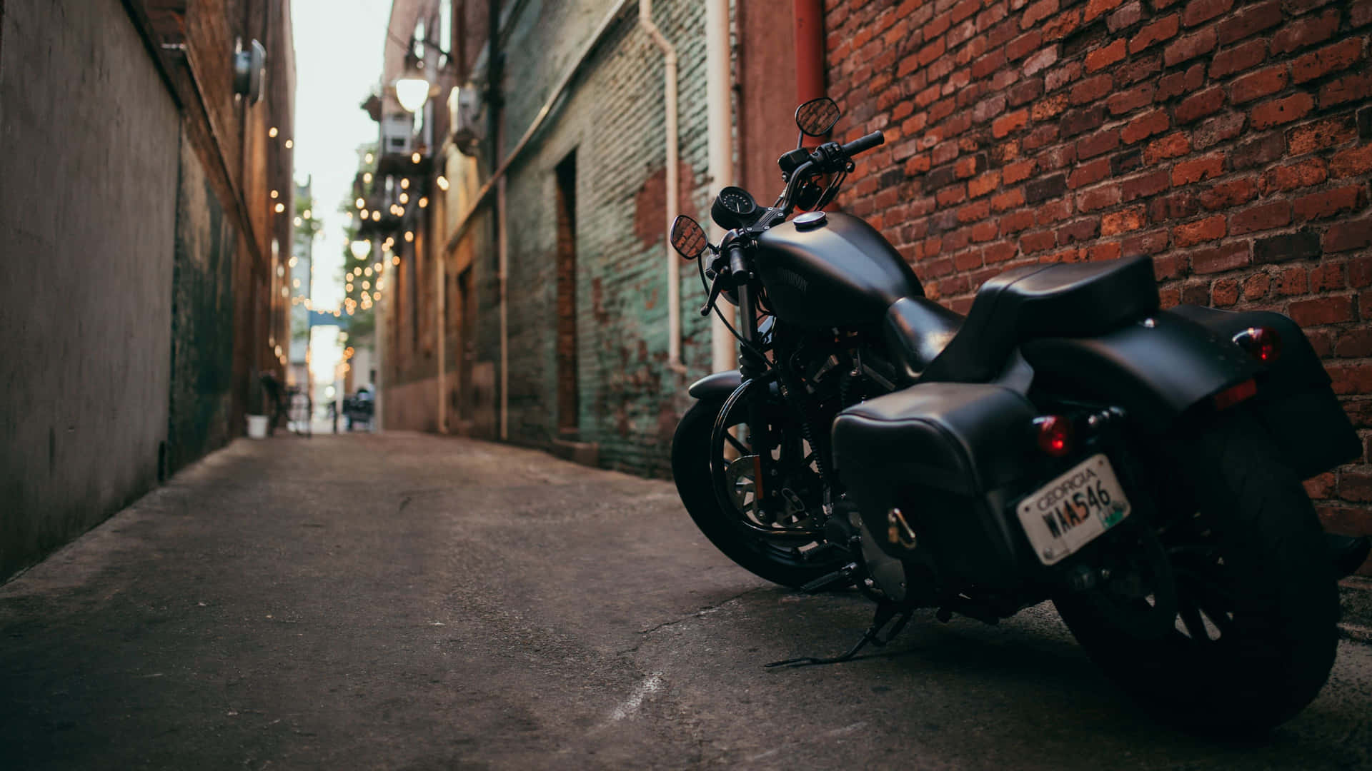 A Black Motorcycle Parked In An Alleyway