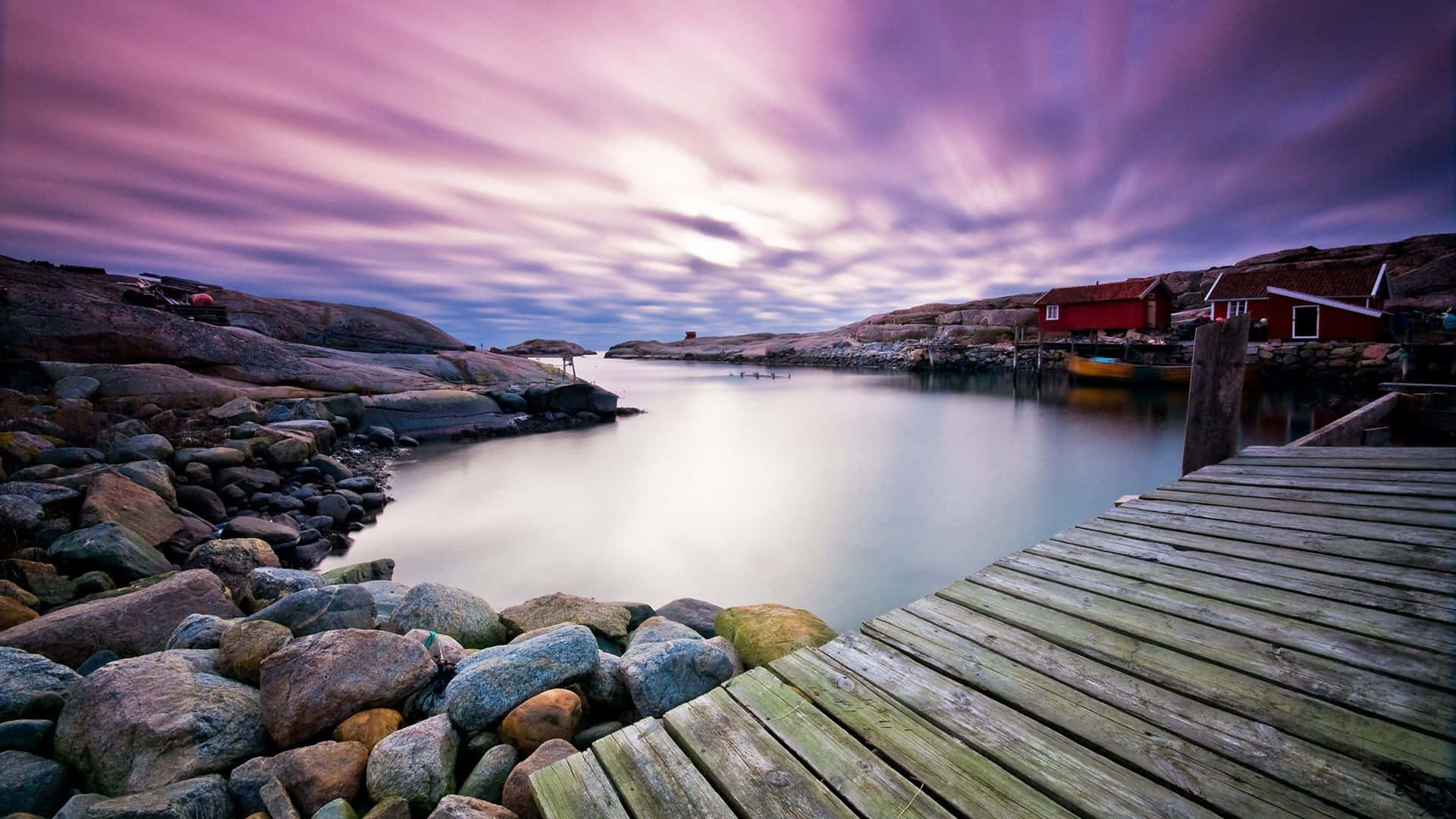A Wooden Dock With A Purple Sky And A Boat