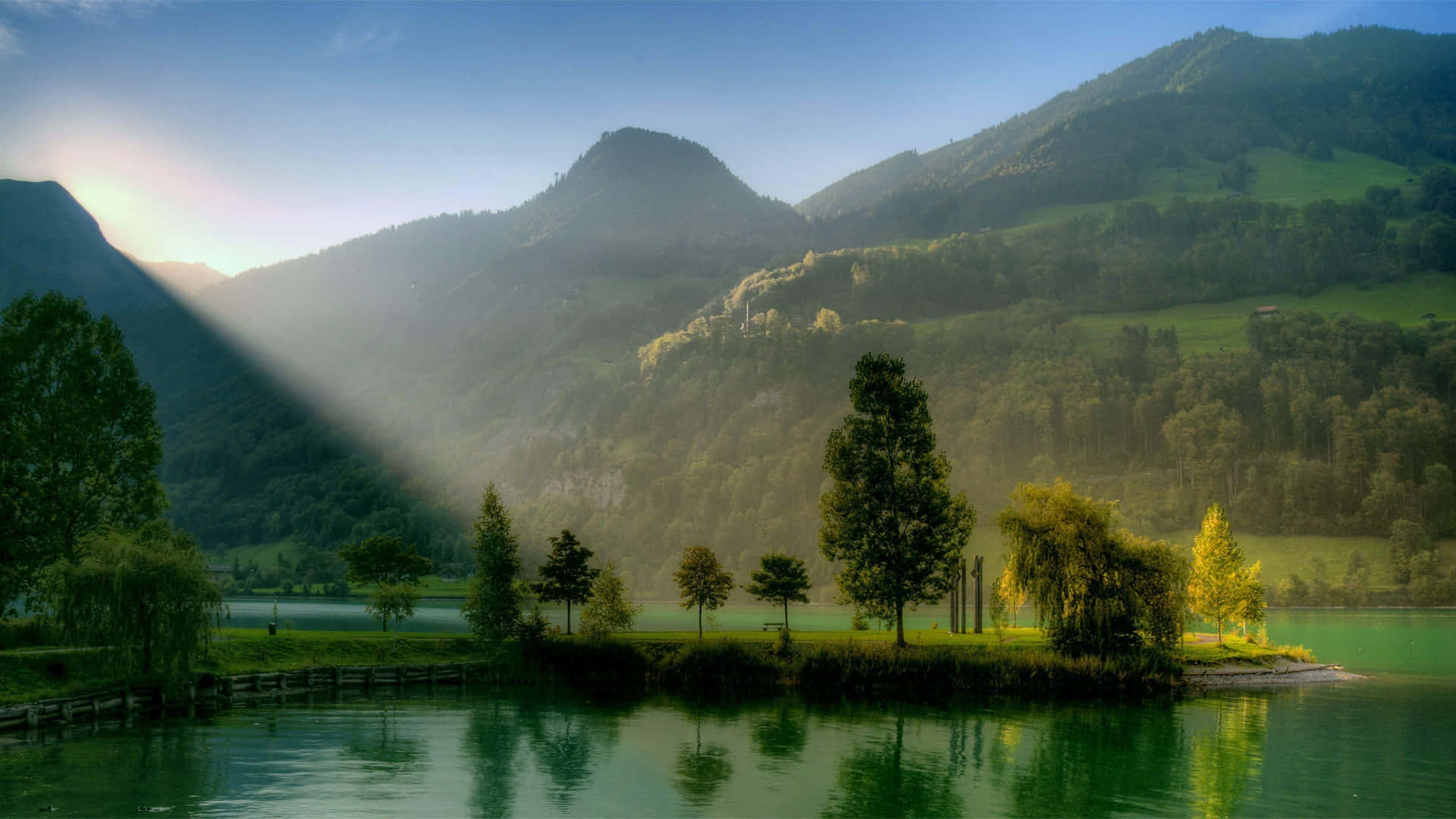 A Lake With Trees And A Sun Beam Shining Through The Trees