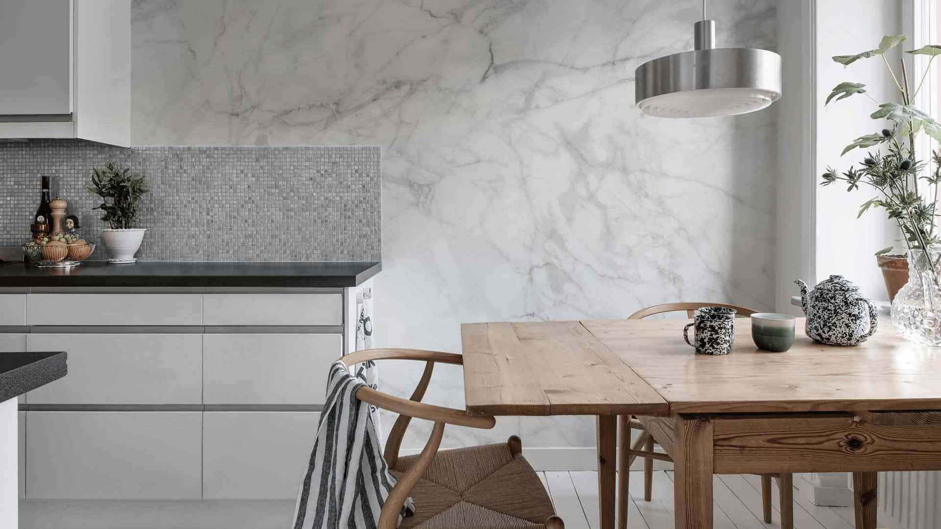 A White Kitchen With Marble Walls And Wooden Table