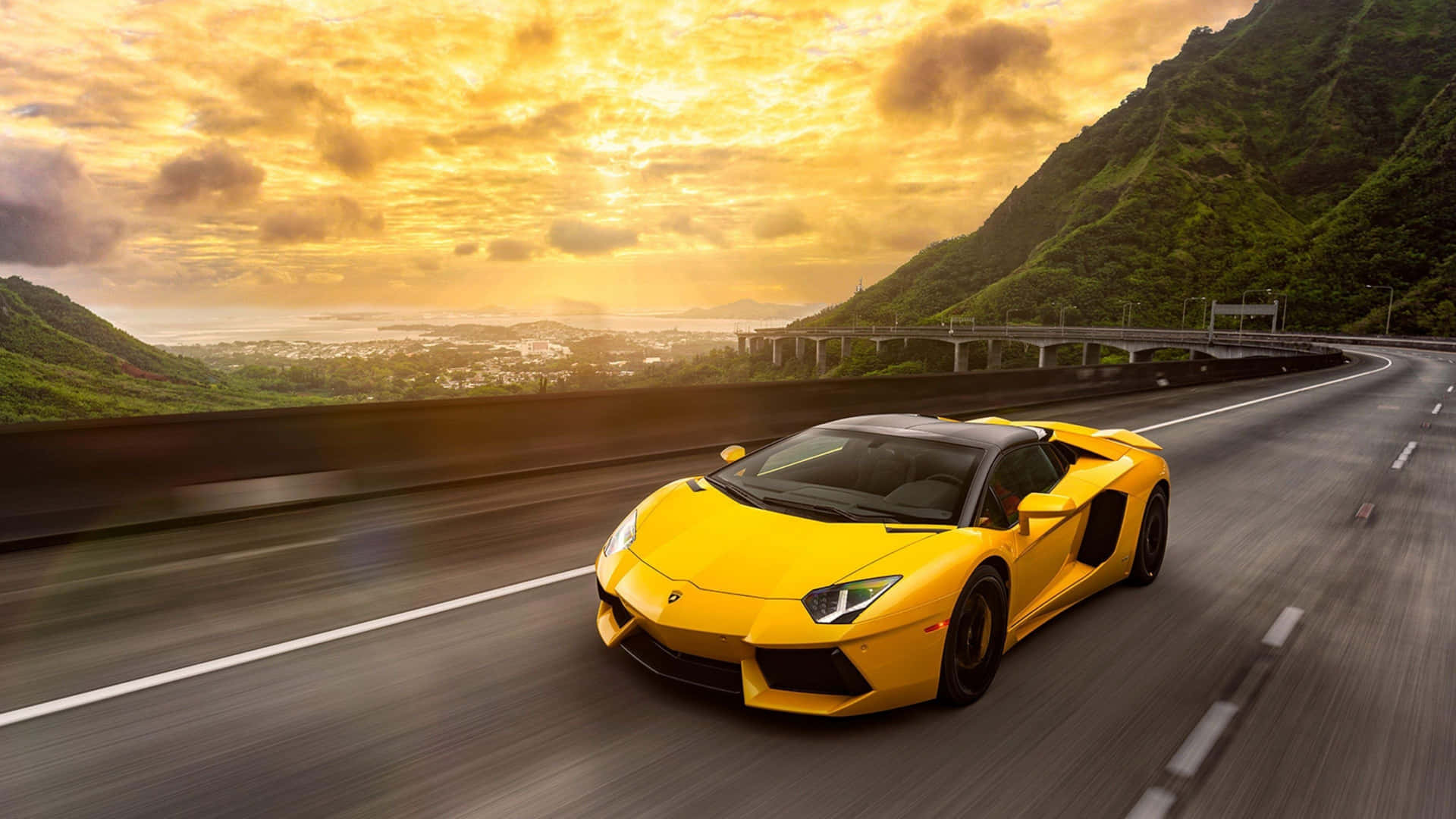 A Yellow Sports Car Driving On A Highway In The Mountains