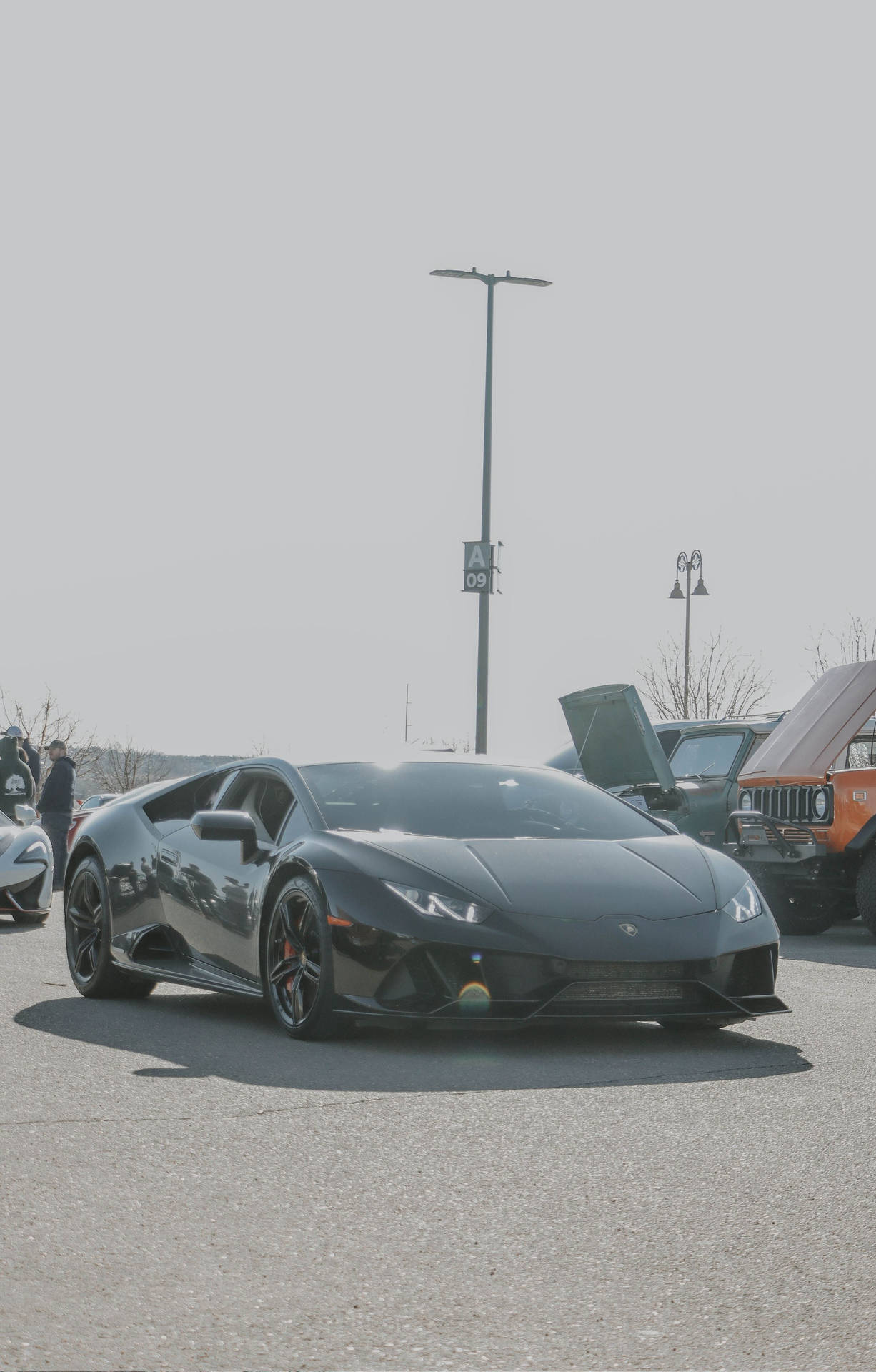 A Black Lamborghini Gt4 Parked In A Parking Lot Wallpaper