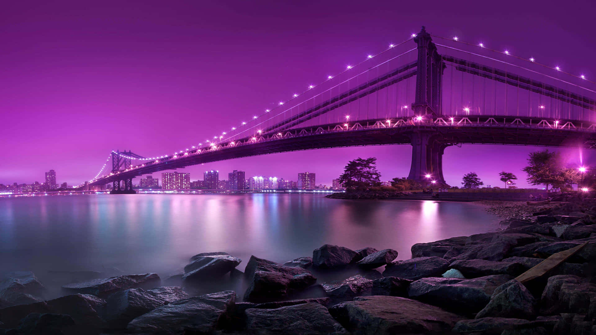 The night skyline of New York City glows from the hustle and bustle of the city. Wallpaper