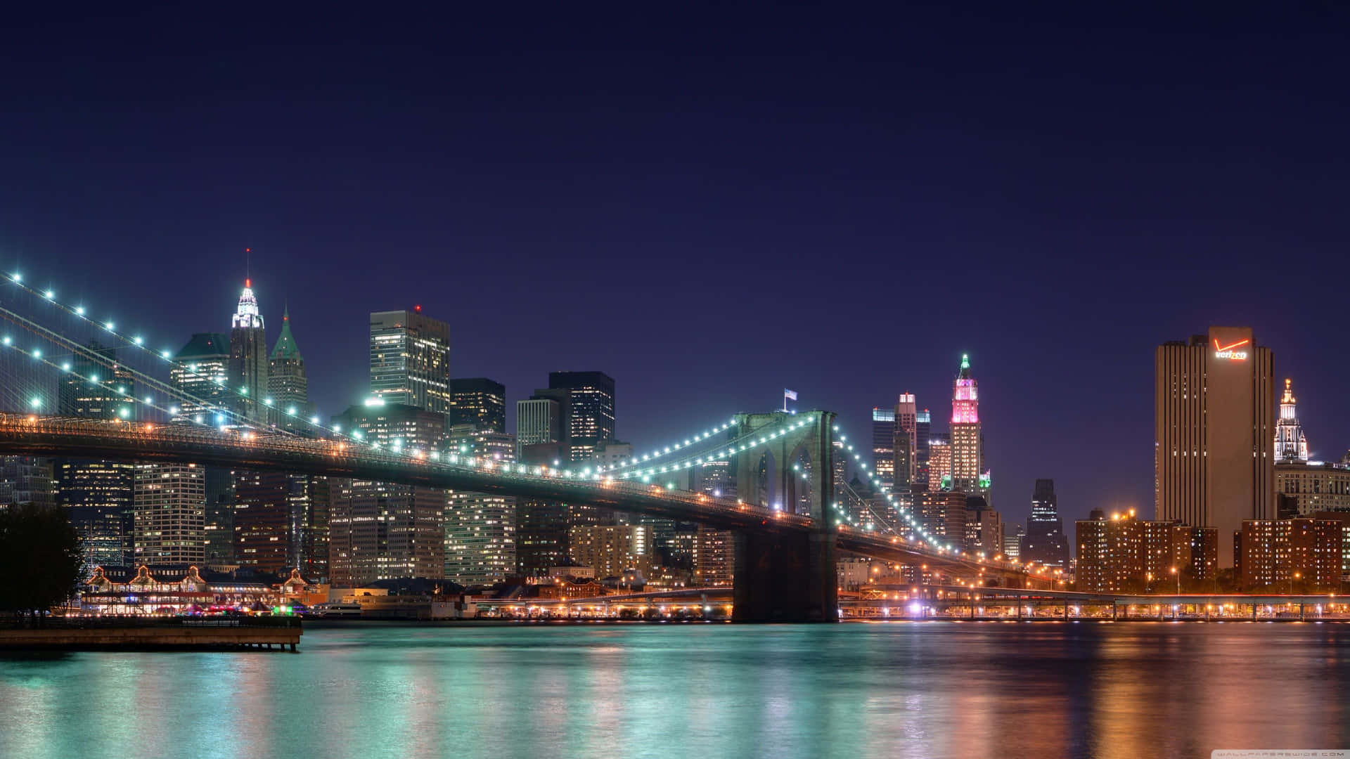 Brooklyn Bridge Om Natten med de skinnende Bylygter Wallpaper