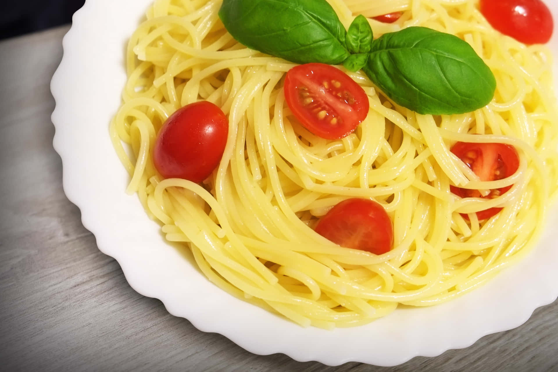 Download A Plate Of Spaghetti With Tomatoes And Basil | Wallpapers.com
