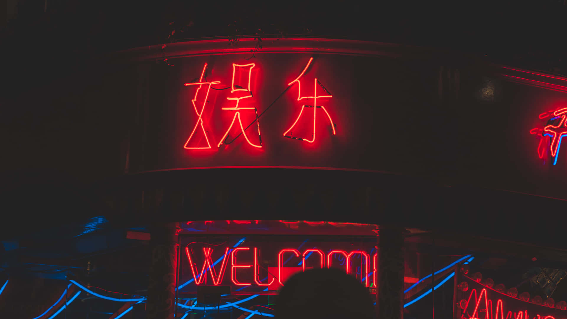 A Neon Sign On A Building Wallpaper