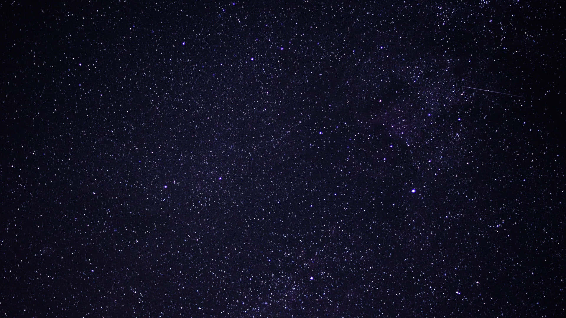 En natudsigt af en stjerneklar himmel, fyldt med glimtende stjerner. Wallpaper