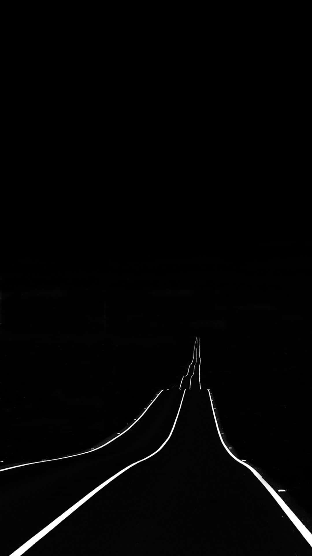 Unafoto En Blanco Y Negro De Una Carretera Con Luces Fondo de pantalla