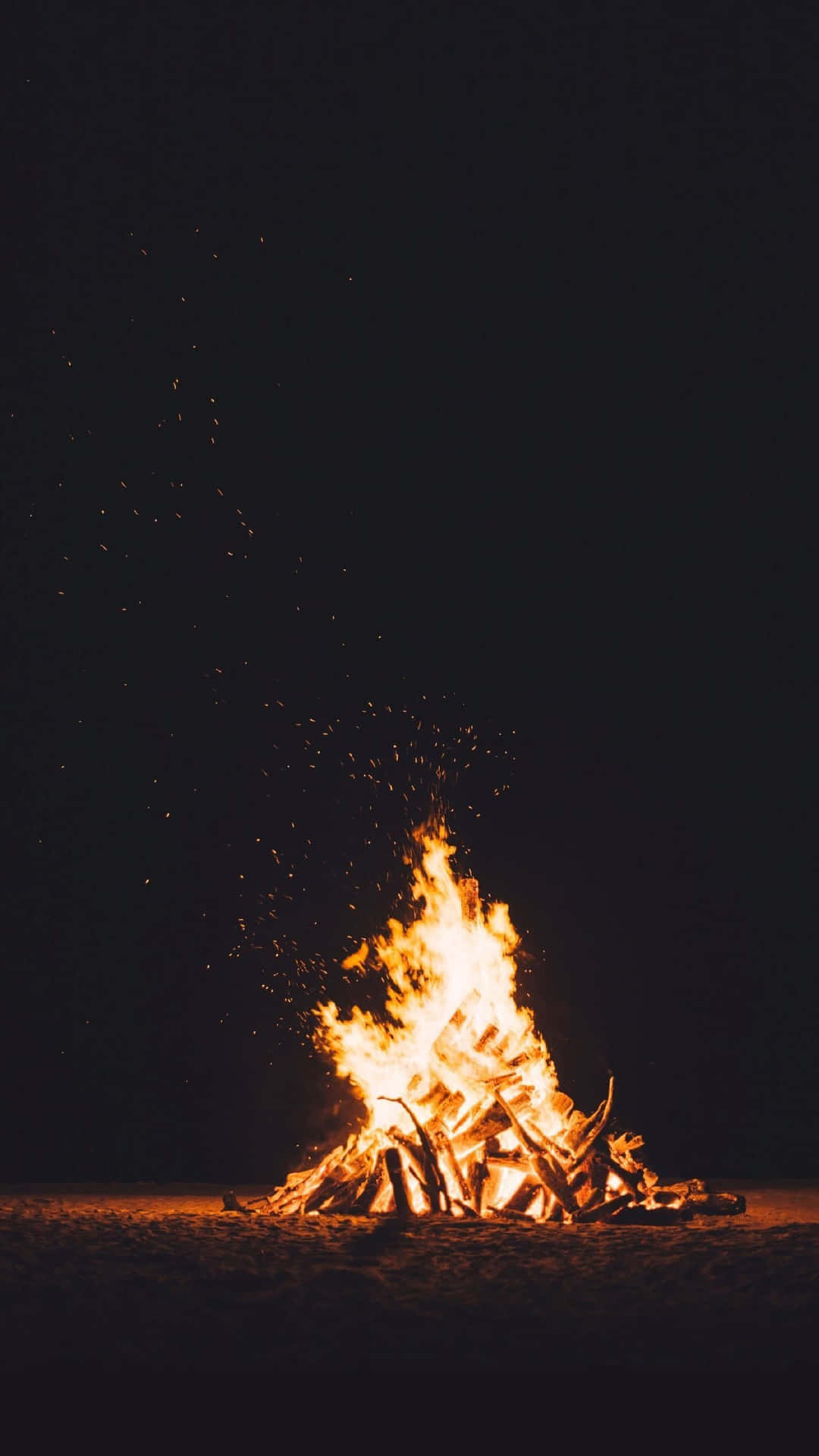 A Bonfire On The Beach At Night Wallpaper