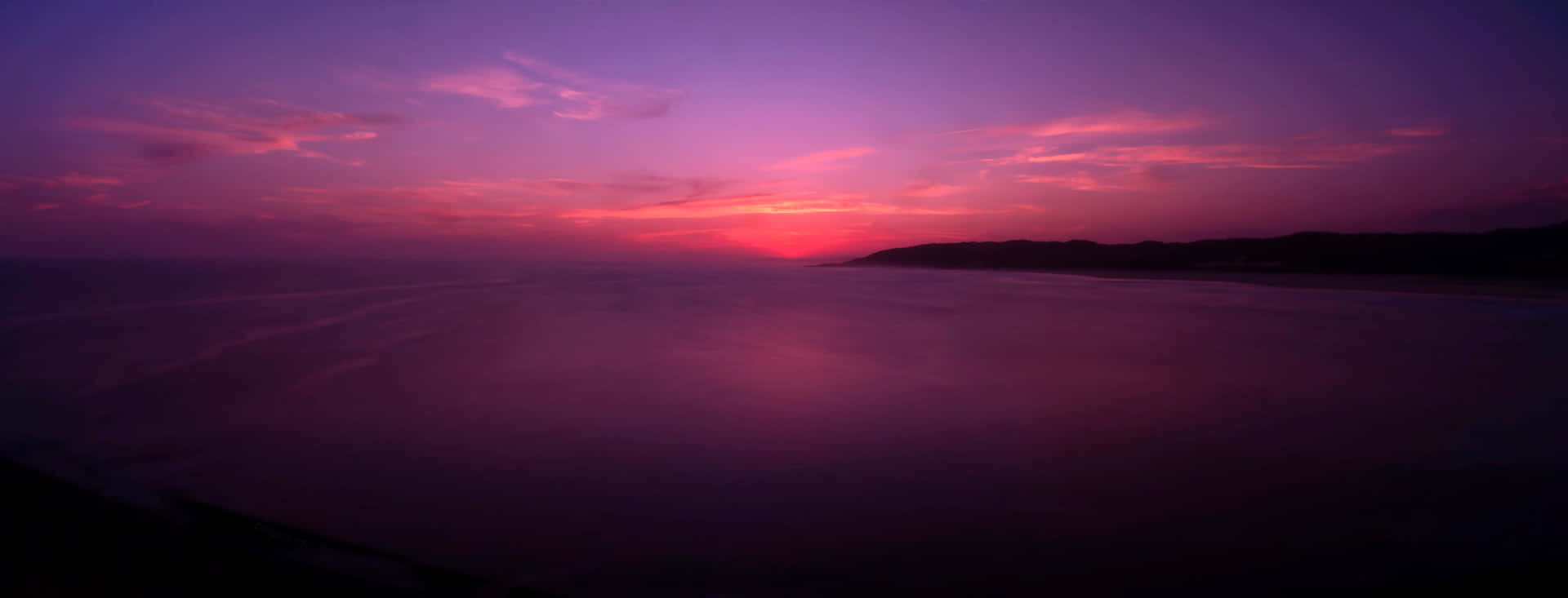 A Purple Sunset Over The Ocean Wallpaper