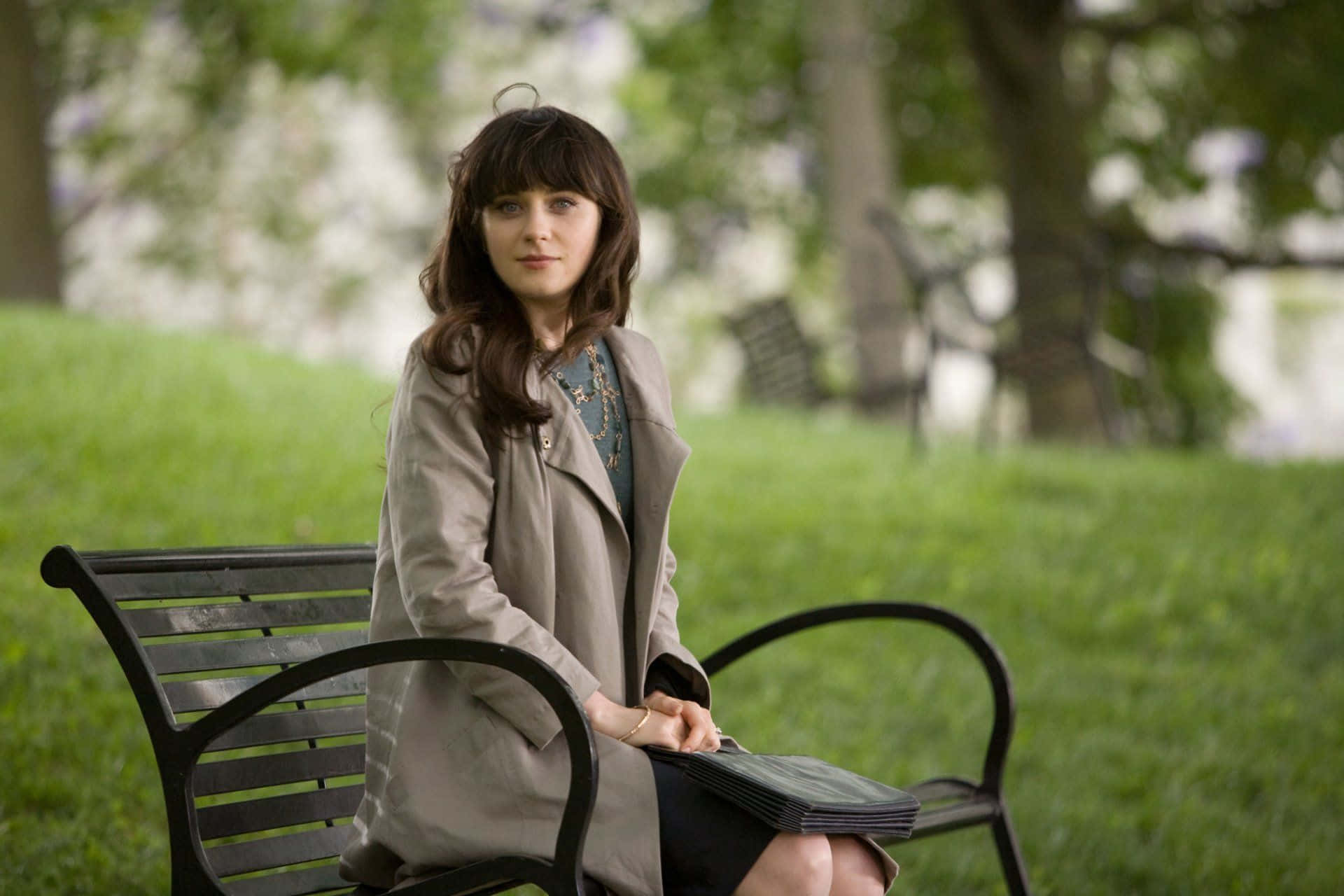A Woman Sitting On A Bench In A Park