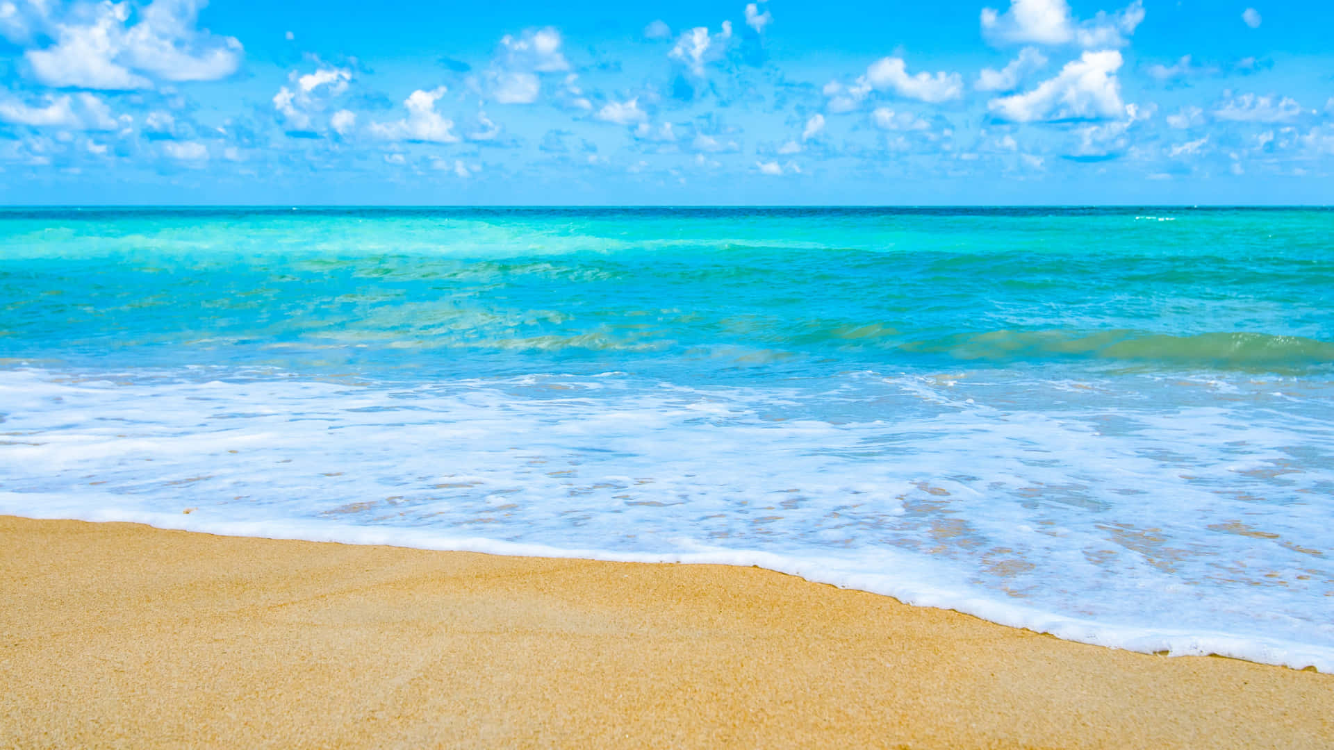 A Sandy Beach With A Blue Ocean