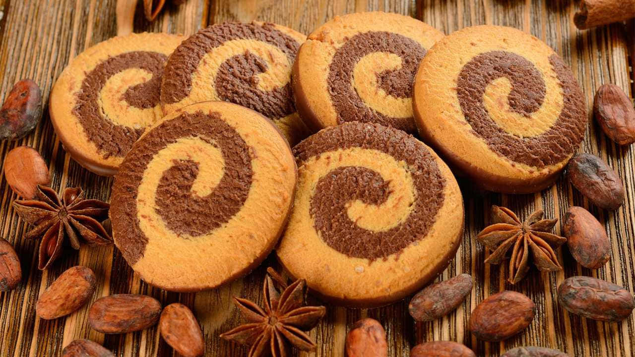 A Group Of Cookies With Swirls On Top Of A Wooden Table