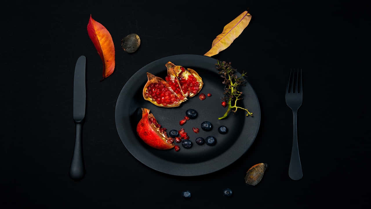 A Plate With Pomegranate And Blueberries