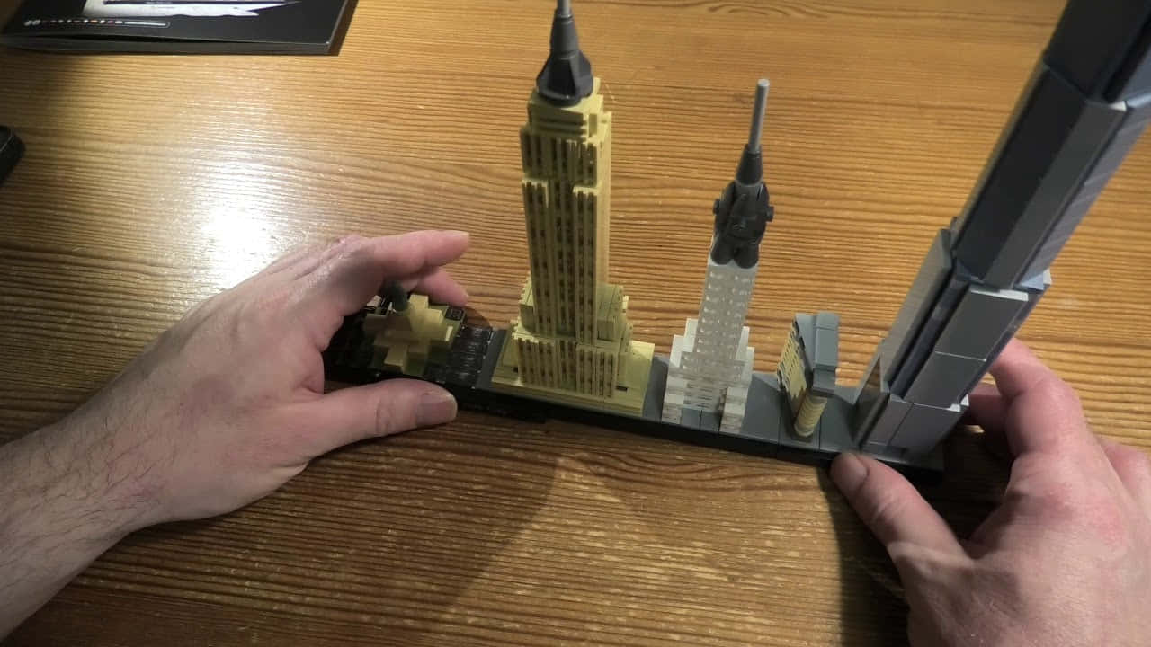 A Person Holding A Lego Model Of The Empire State Building