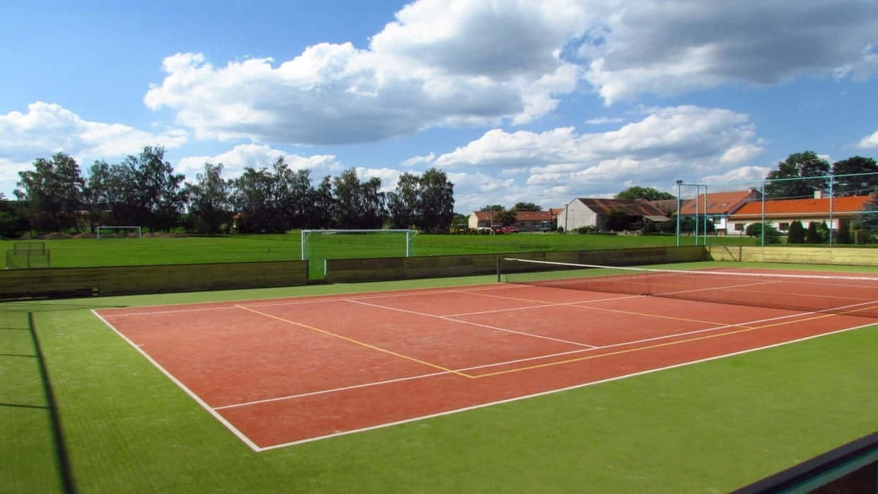 A Tennis Court With A Green Net And A Green Grass