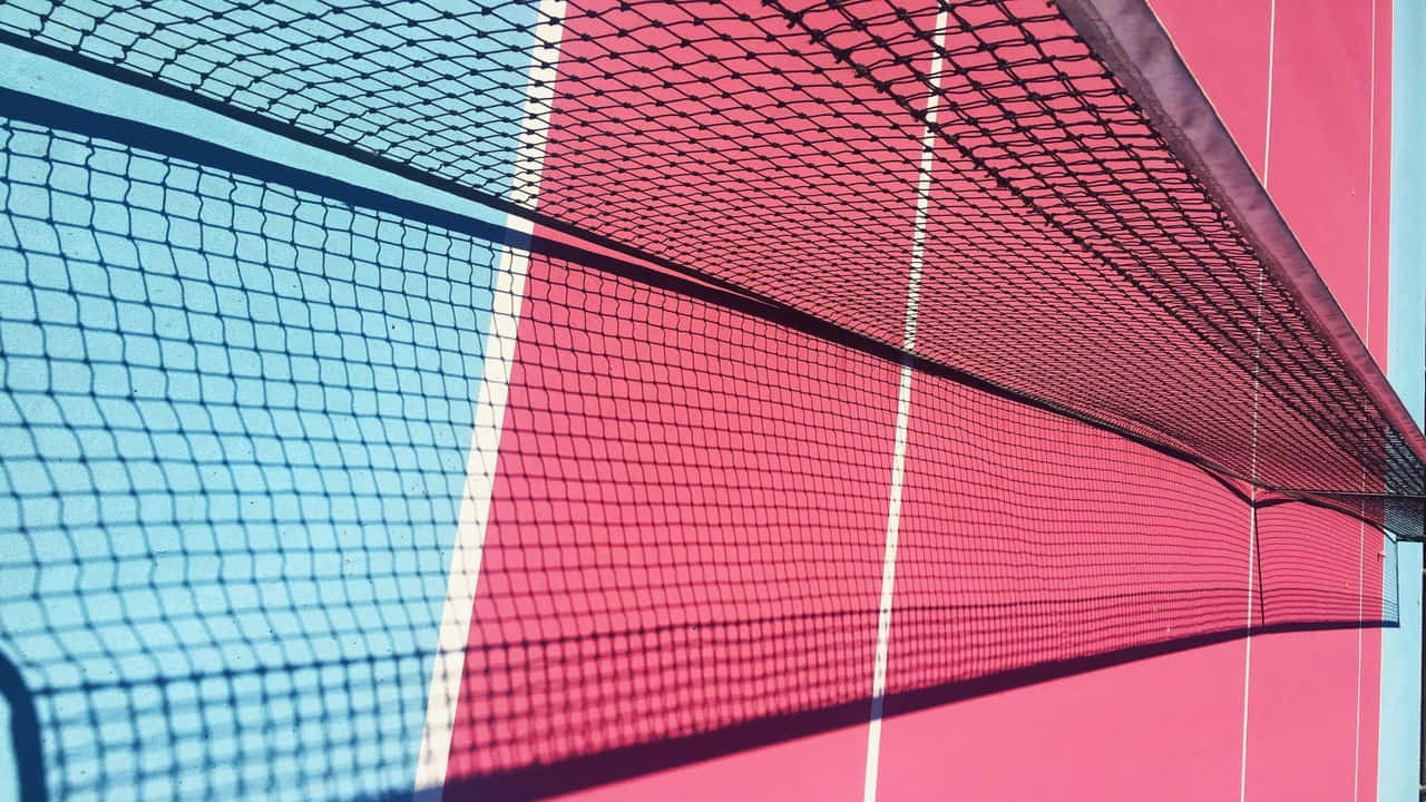 A Net Is Seen Against A Pink And Blue Wall
