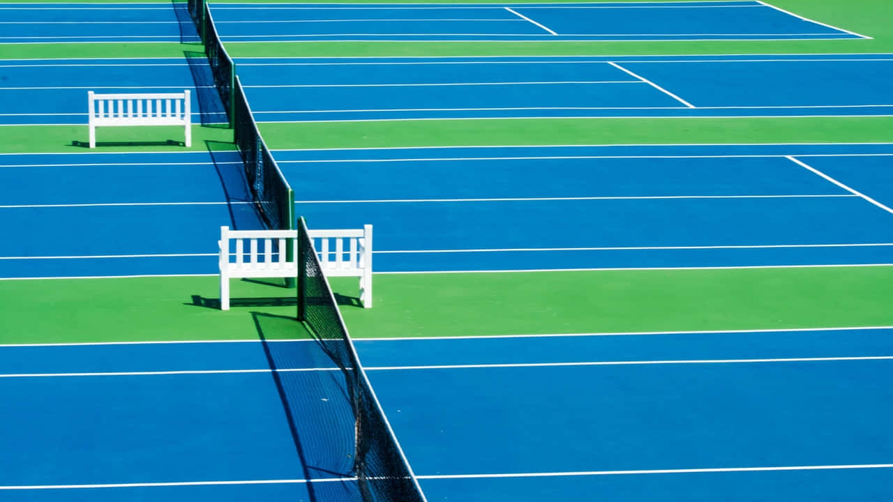 A Tennis Court With A White Bench