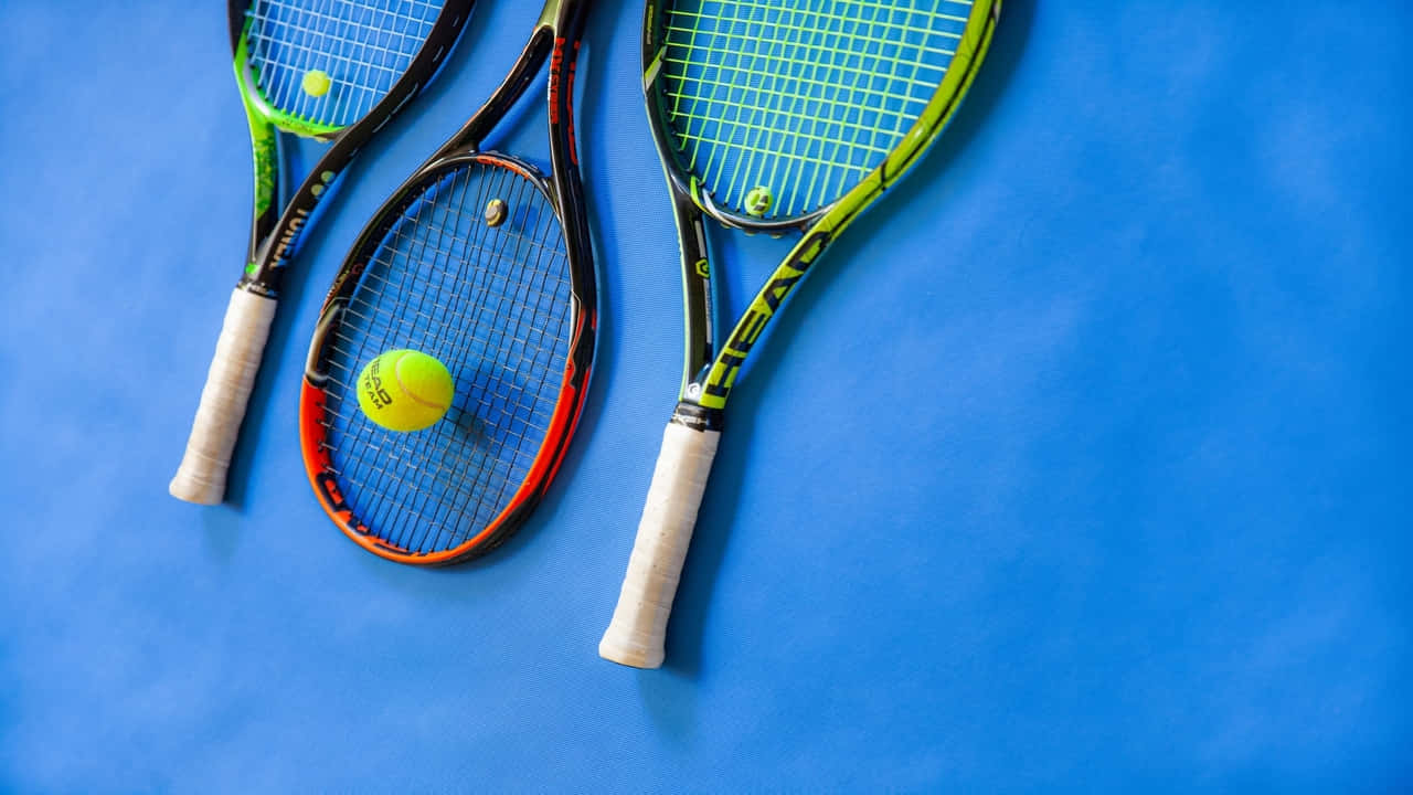 Three Tennis Rackets On A Blue Surface