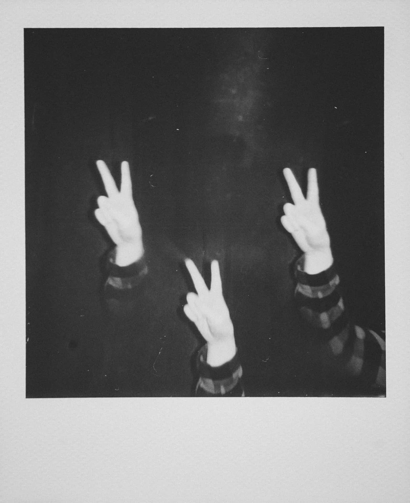 A Black And White Photo Of Three People Making Peace Signs Wallpaper