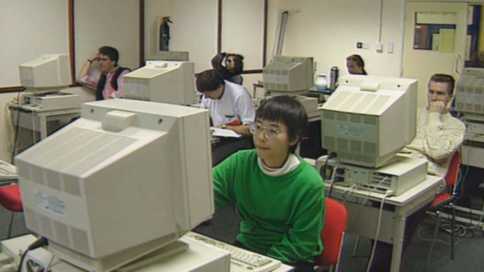 Einegruppe Von Menschen Sitzt Vor Computern Wallpaper
