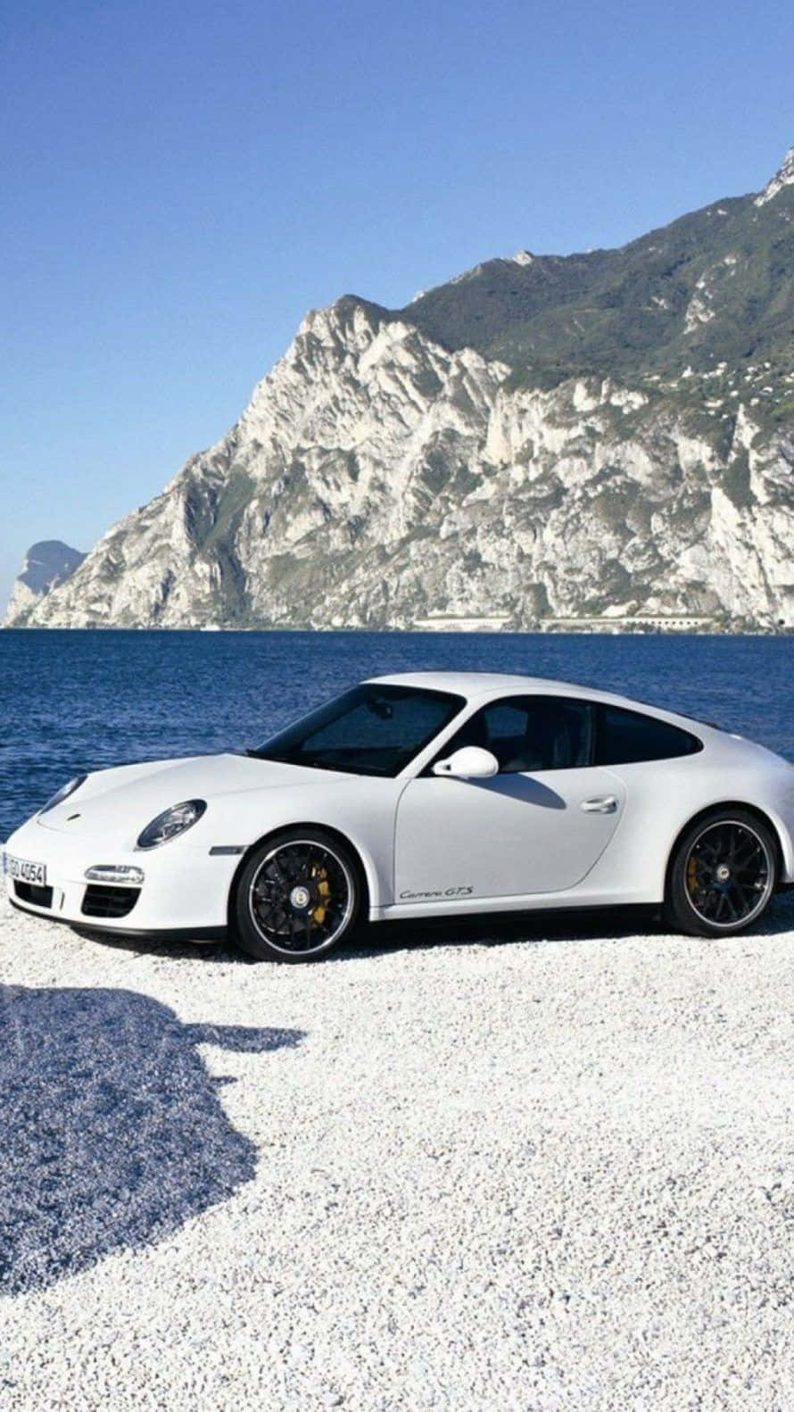 Porsche 911 GTS - en hvid sportsvogn parkeret på stranden. Wallpaper