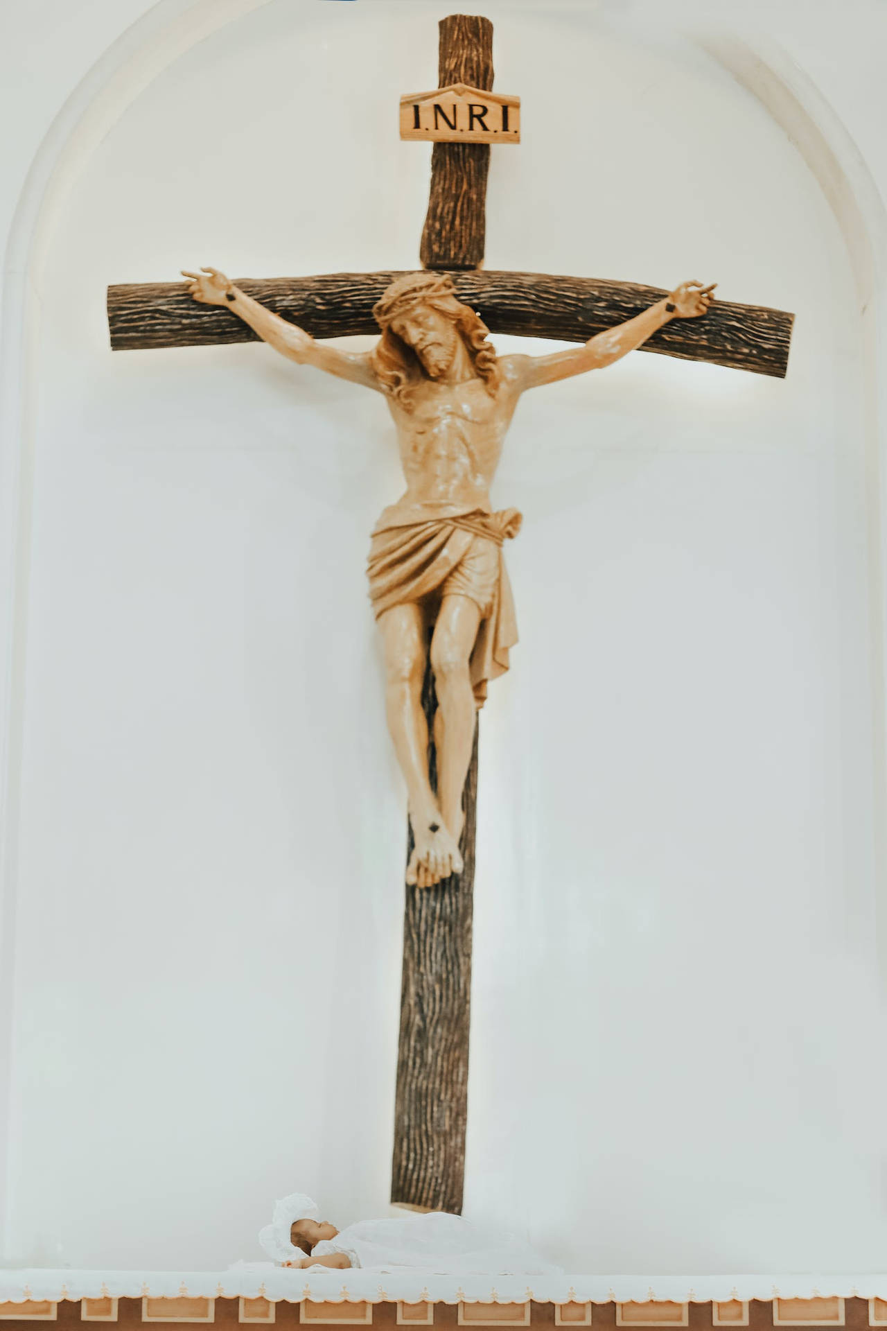 A Baby Underneath Jesus On Cross Wallpaper