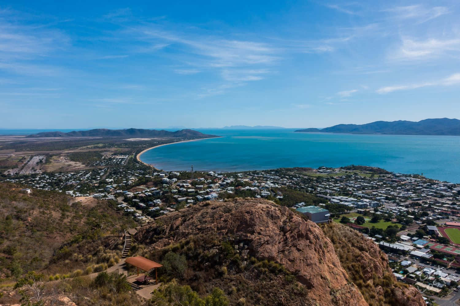 A Breathtaking View Of Townsville's Scenic Beauty - Cityscape Meets Nature Under A Clear Sky Wallpaper