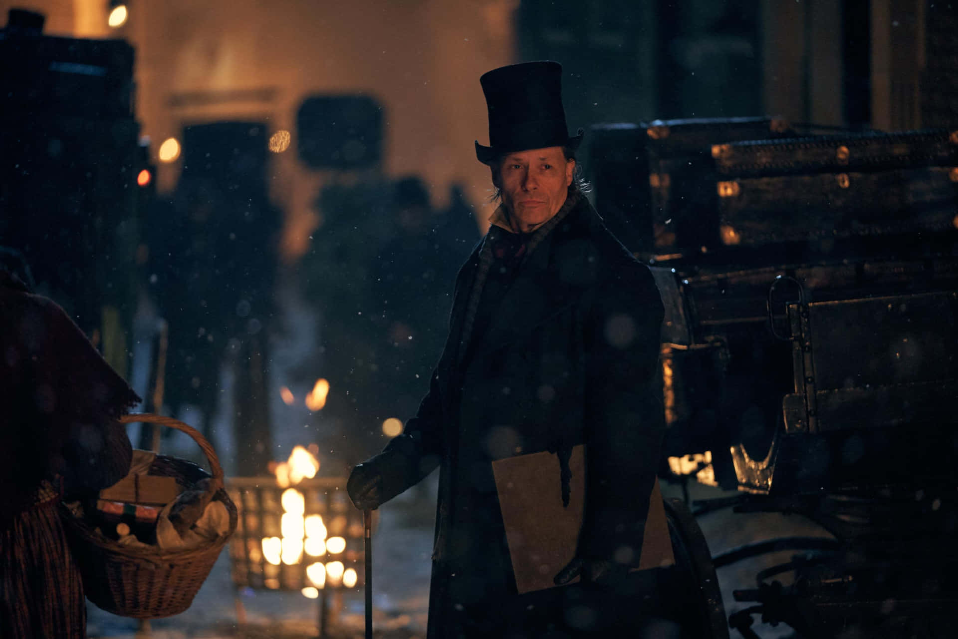 A Man In A Top Hat And A Basket Walking Through The Snow