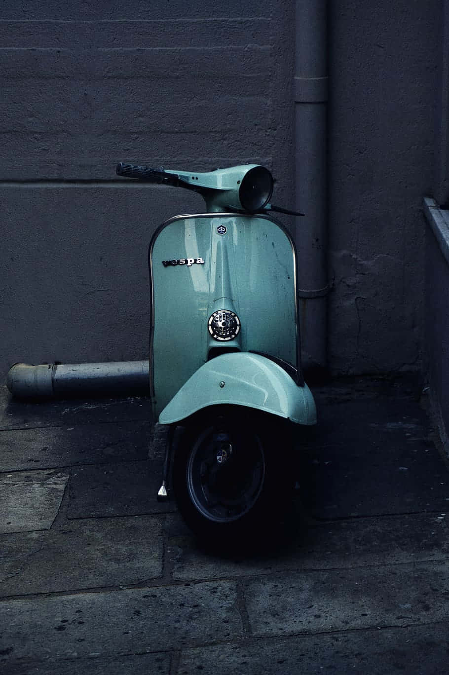A Classic Vespa Parked On A Picturesque Street Wallpaper